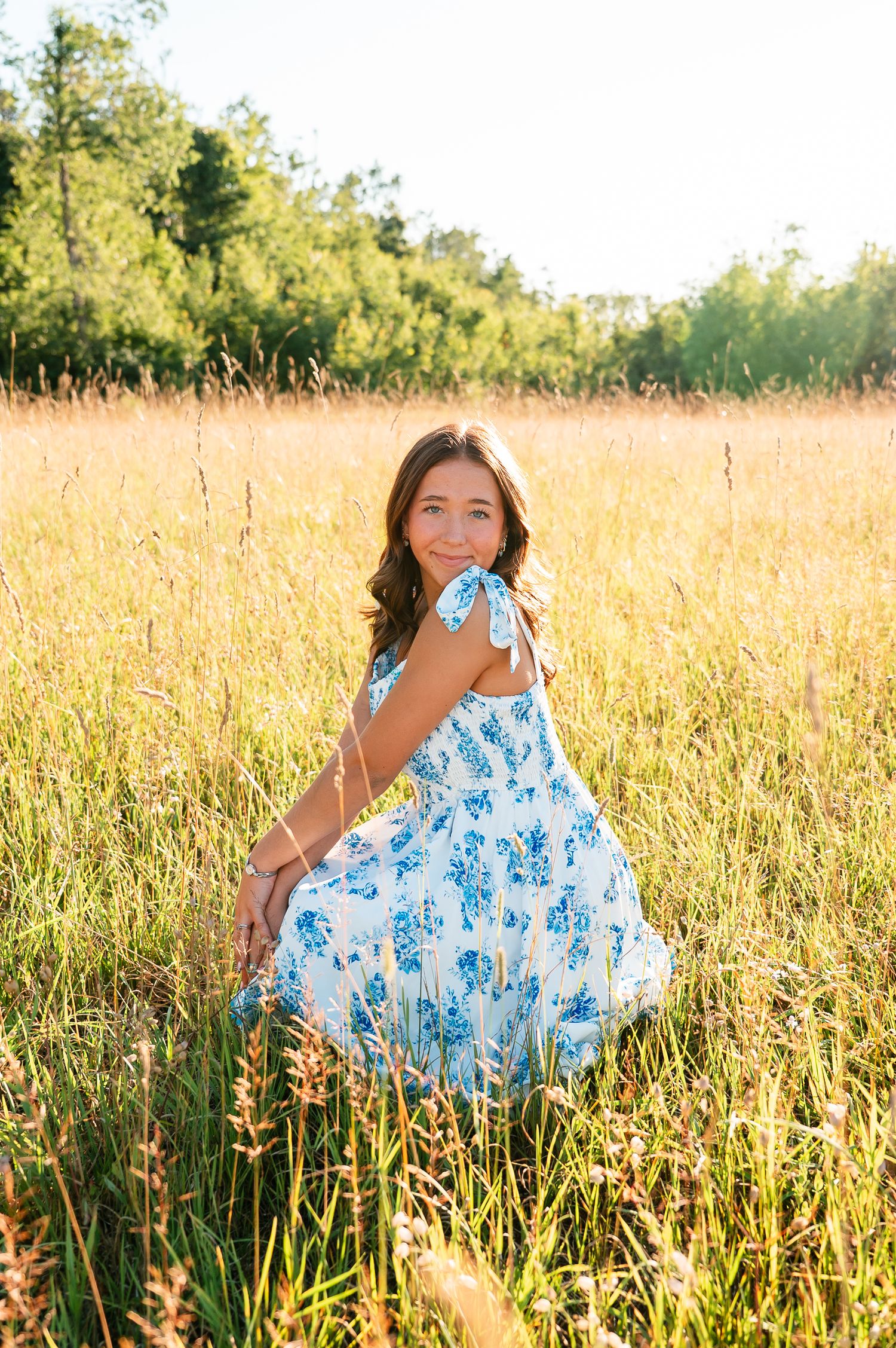 A flowing blue and white sundress catches the sunlight in a golden summer field.