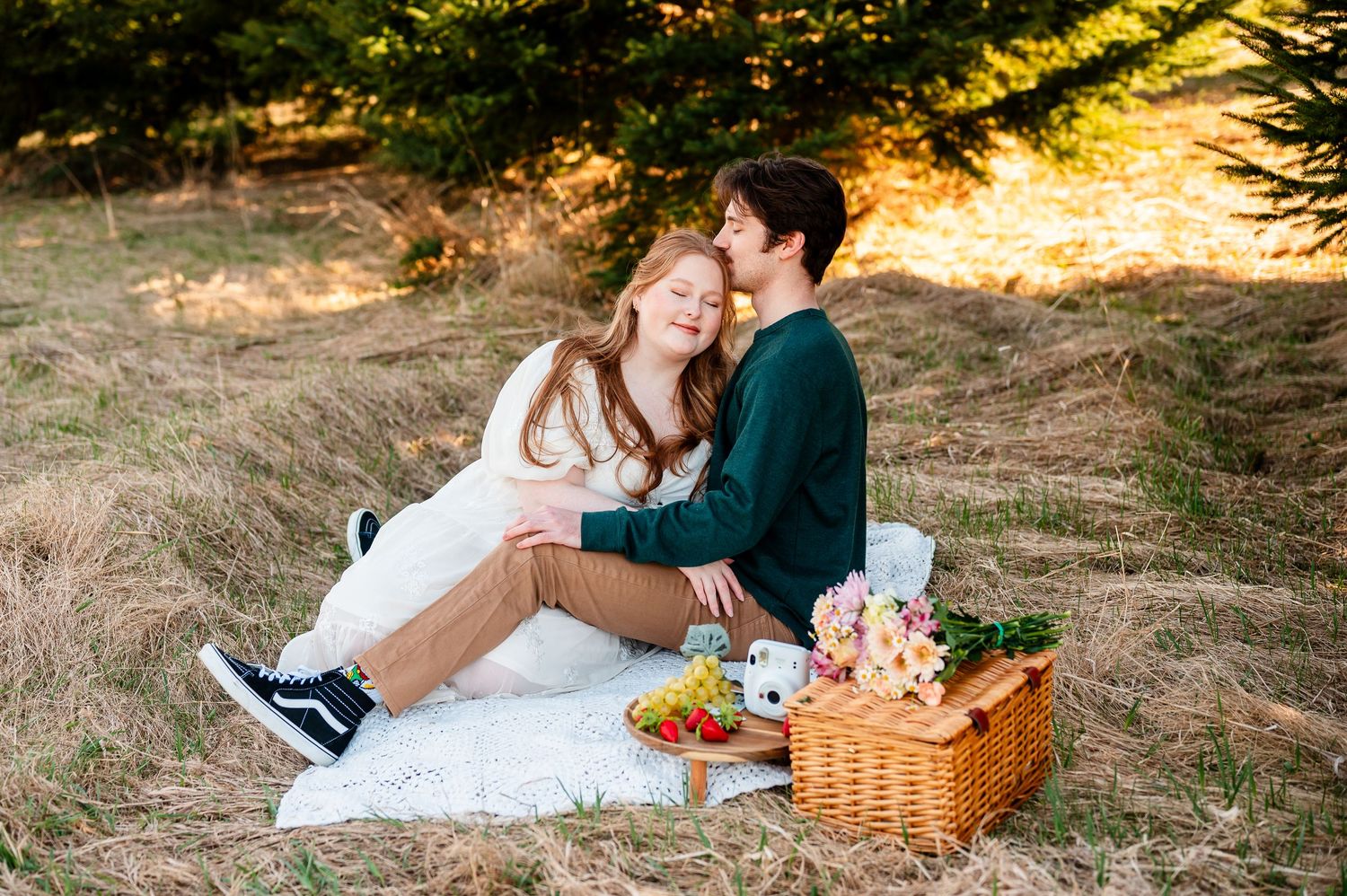 A romantic outdoor picnic setup with a basket and blanket in warm sunset lighting.