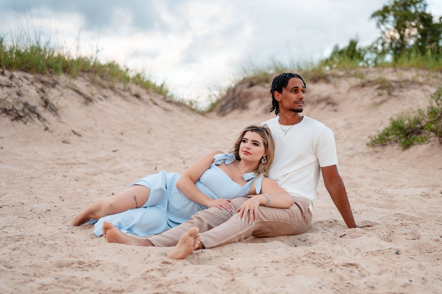 Romantic beach photoshoot with couple relaxing on the dunes in Northern Michigan.