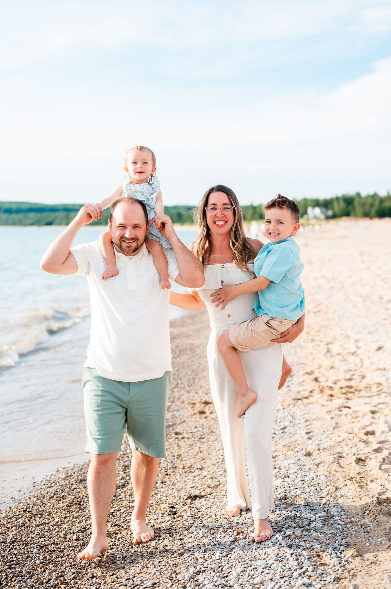 Happy family enjoying a playful moment together on a sunny beach.
