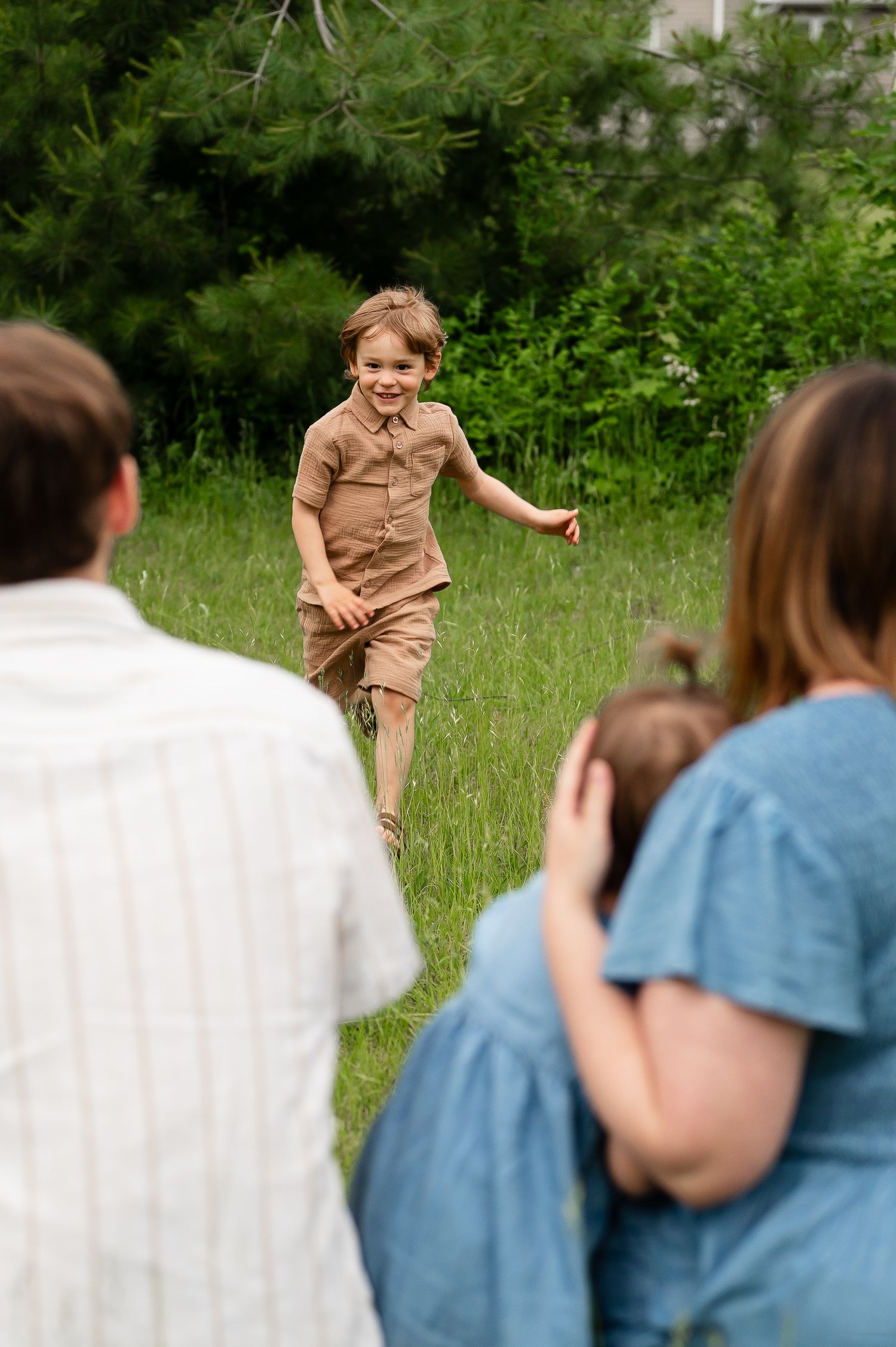 Playful scene in a grassy field as family members engage in a fun outdoor activity.