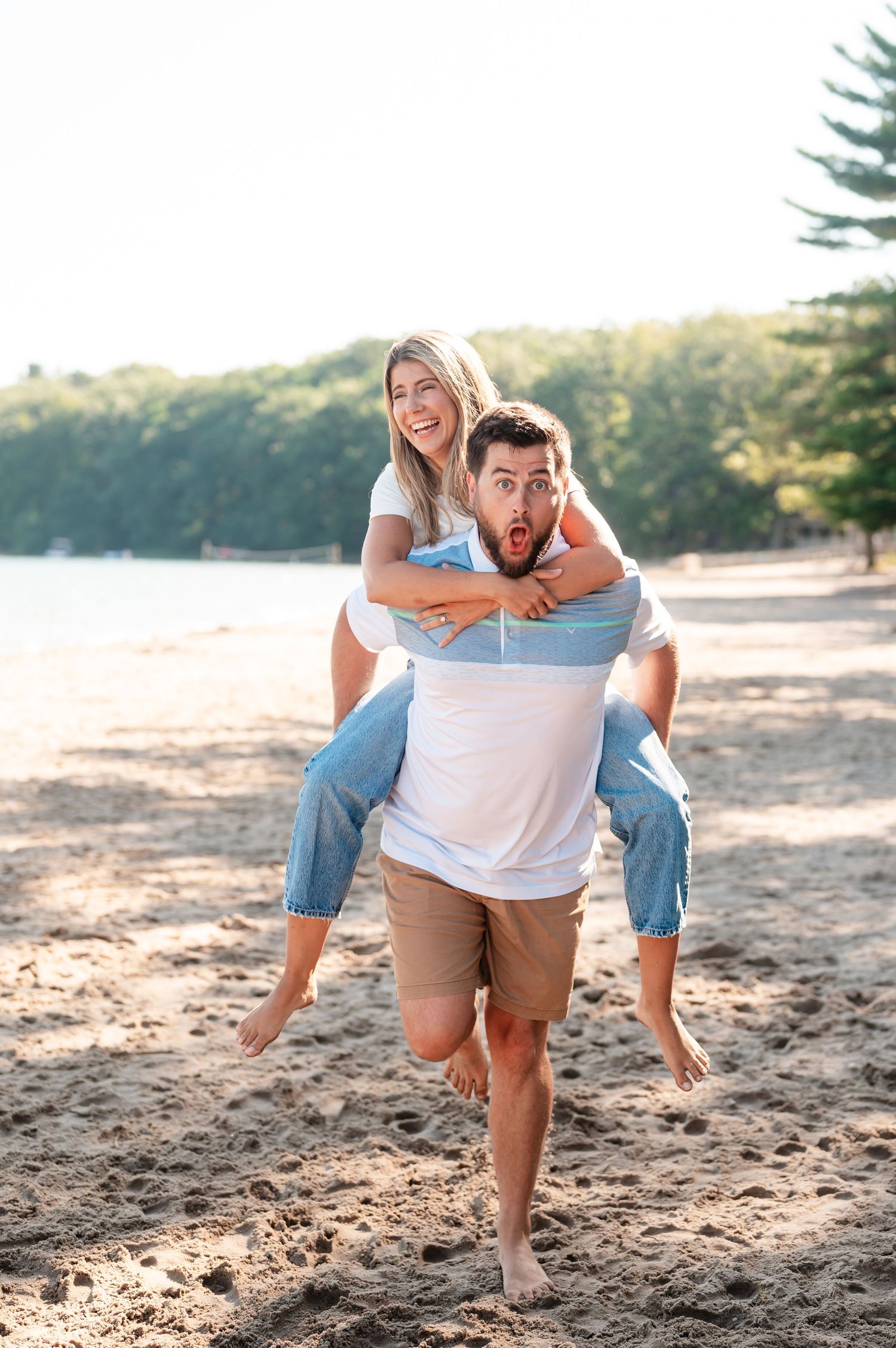 Playful piggyback ride moment captured on sunny beach.