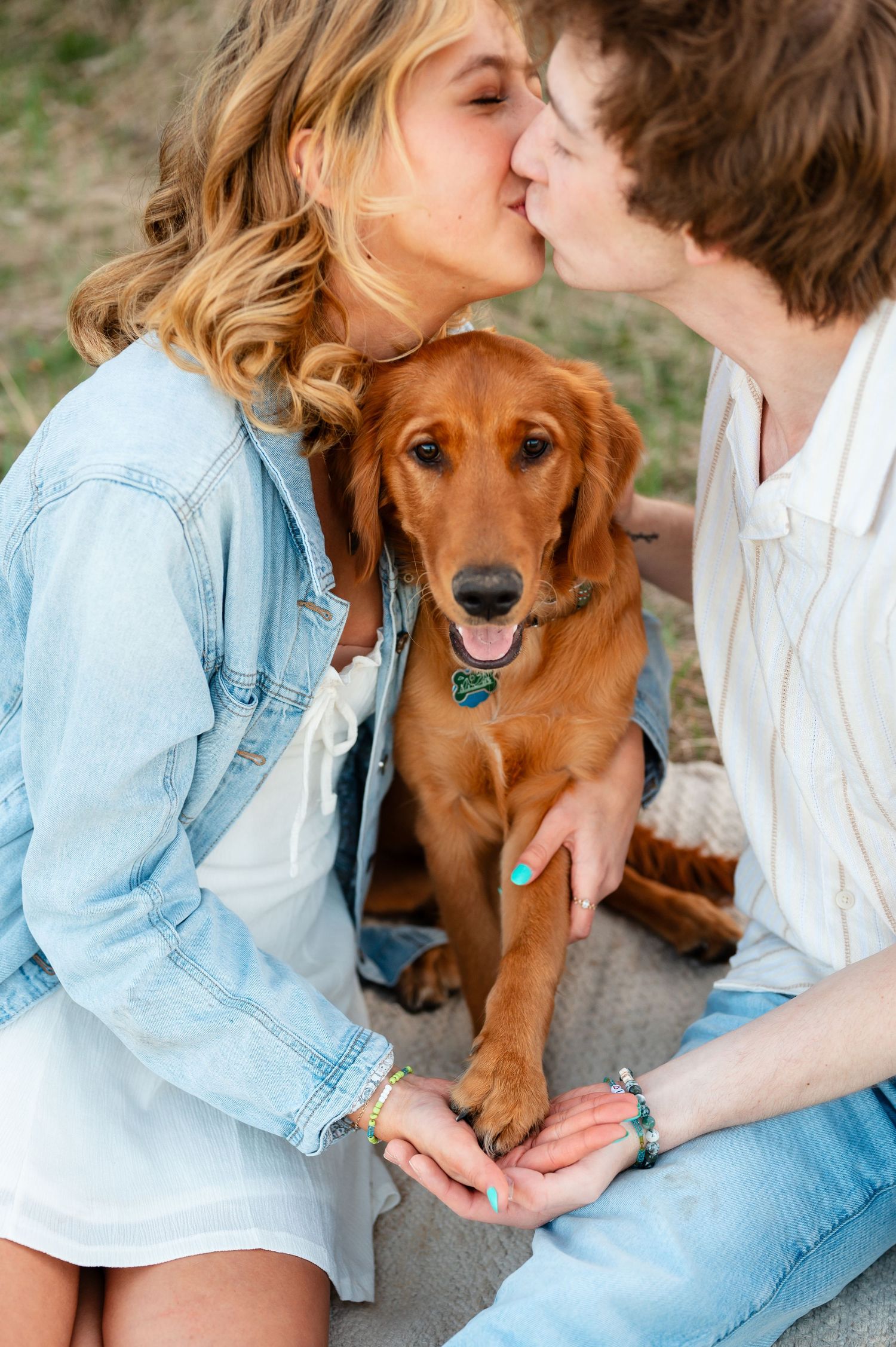 Happy couple sharing tender moments with their playful golden retriever puppy.