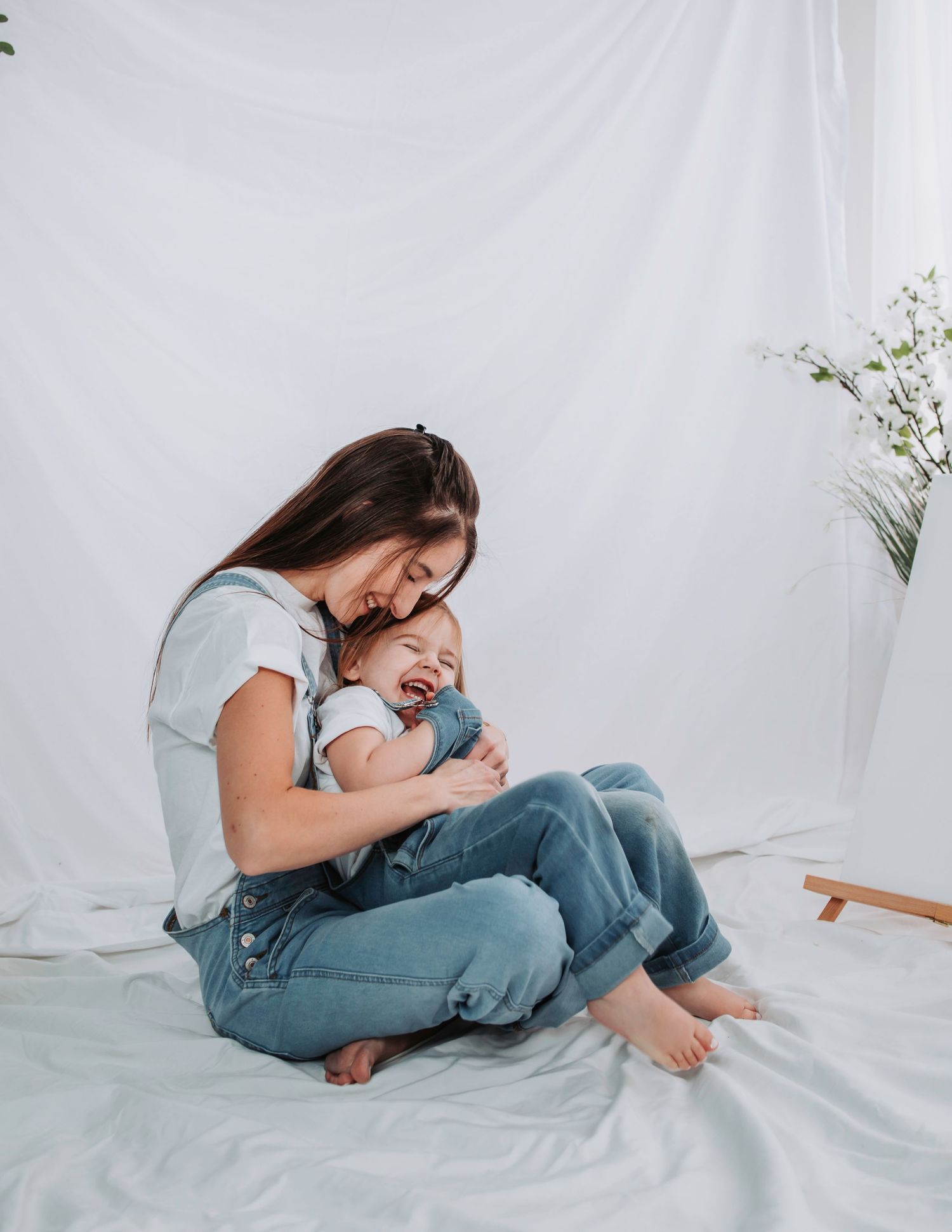 Joyful bonding moments between parent and child on white floor setting.