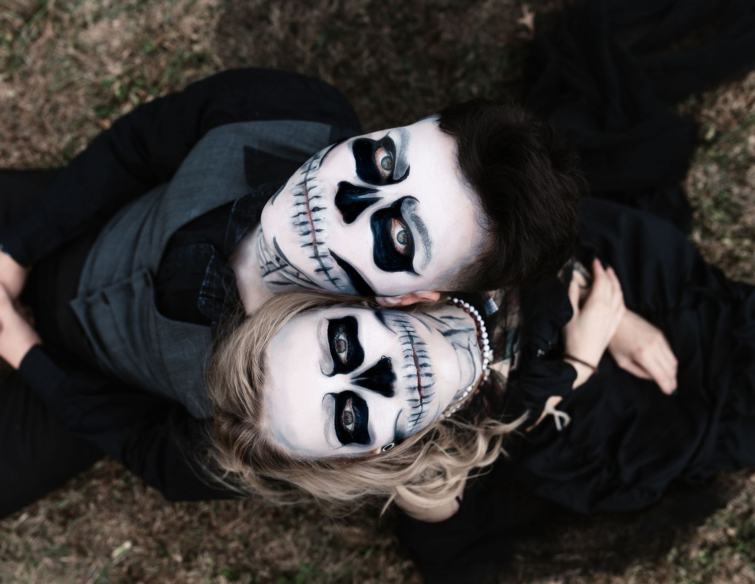 Close-up portrait of skull face paint makeup against dark background.