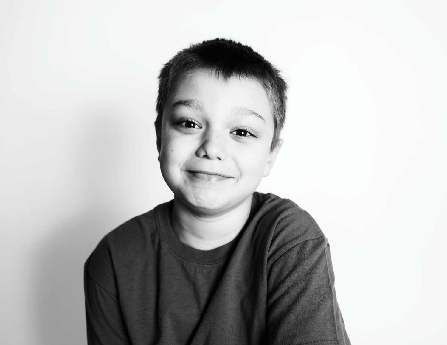 A casual black and white portrait showing a gentle smile and relaxed pose.