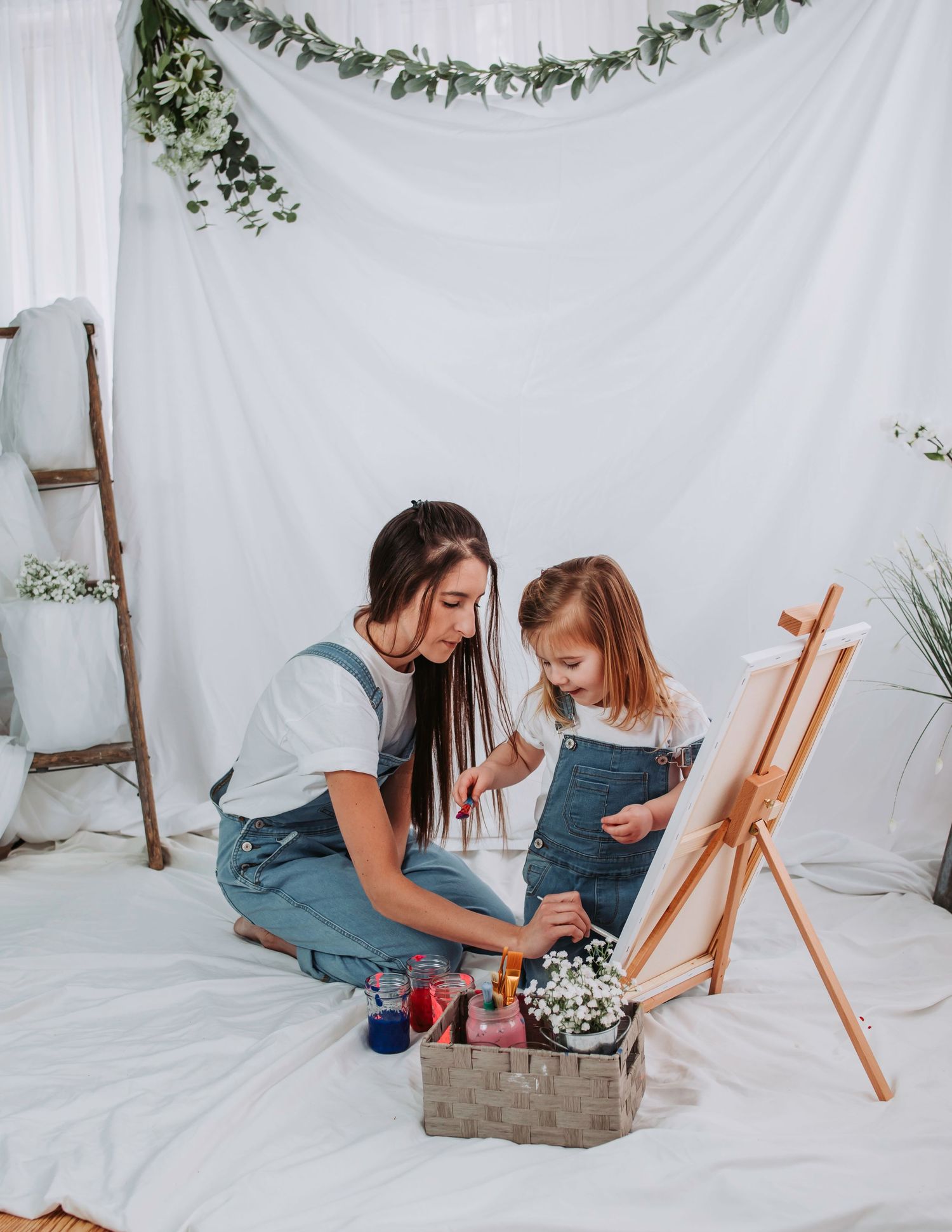 Creative painting session with art supplies and easel on white background.