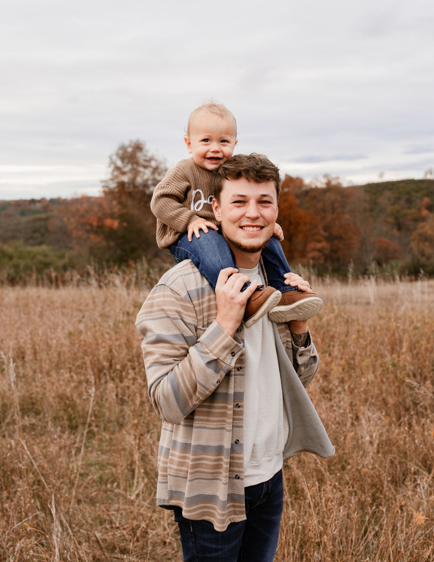 Playful interactions in a fall field with dried grass and cloudy skies.
