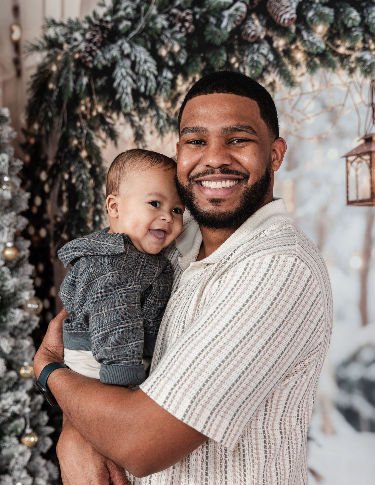 Father and child share joyful moment together against winter holiday backdrop.