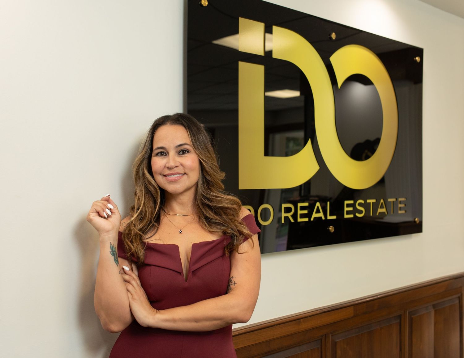 Professional posing confidently in front of gold office signage.