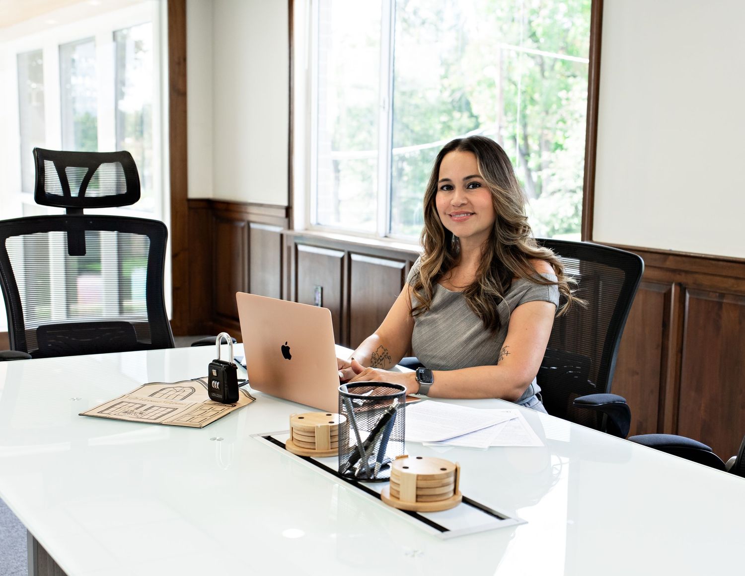 Person working at a desk in a modern office with wooden wall paneling.