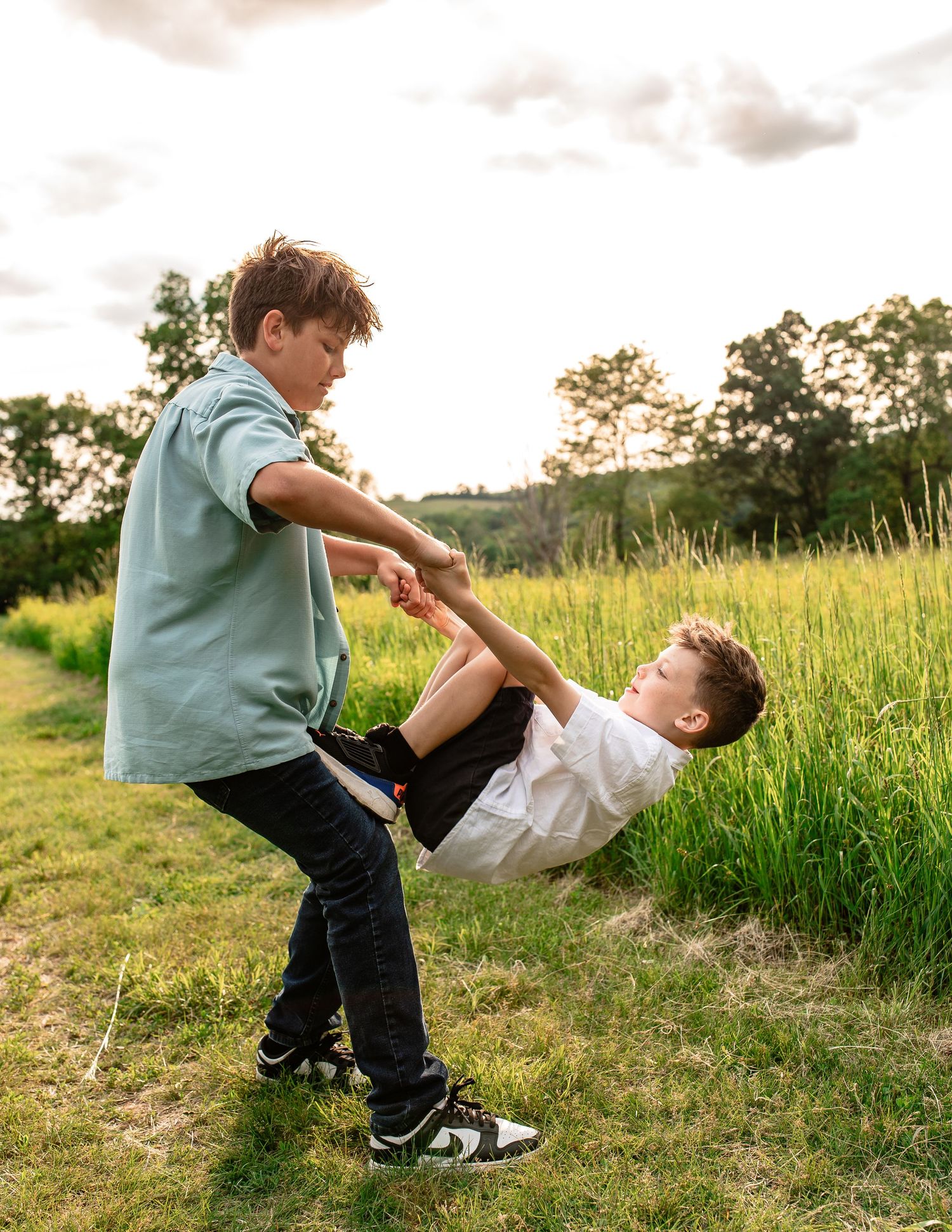Playful moment captured in a grassy field with children engaged in energetic movement.