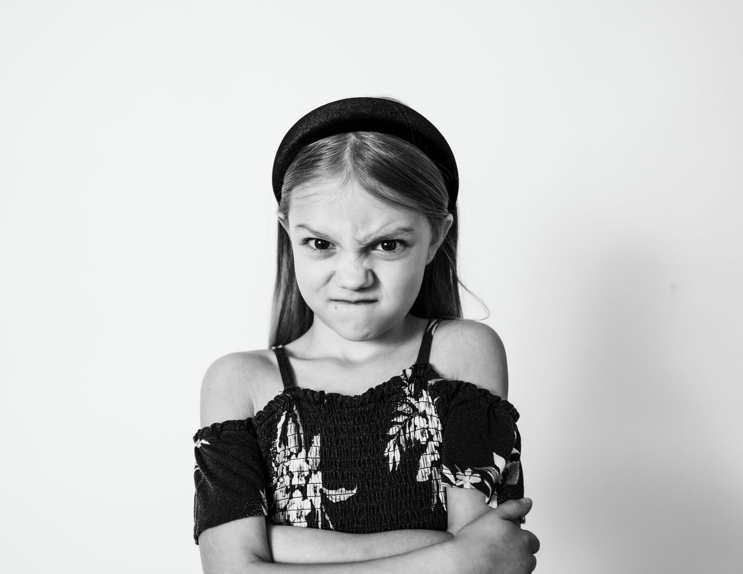 A dramatic black and white portrait with crossed arms and an expressive pose.