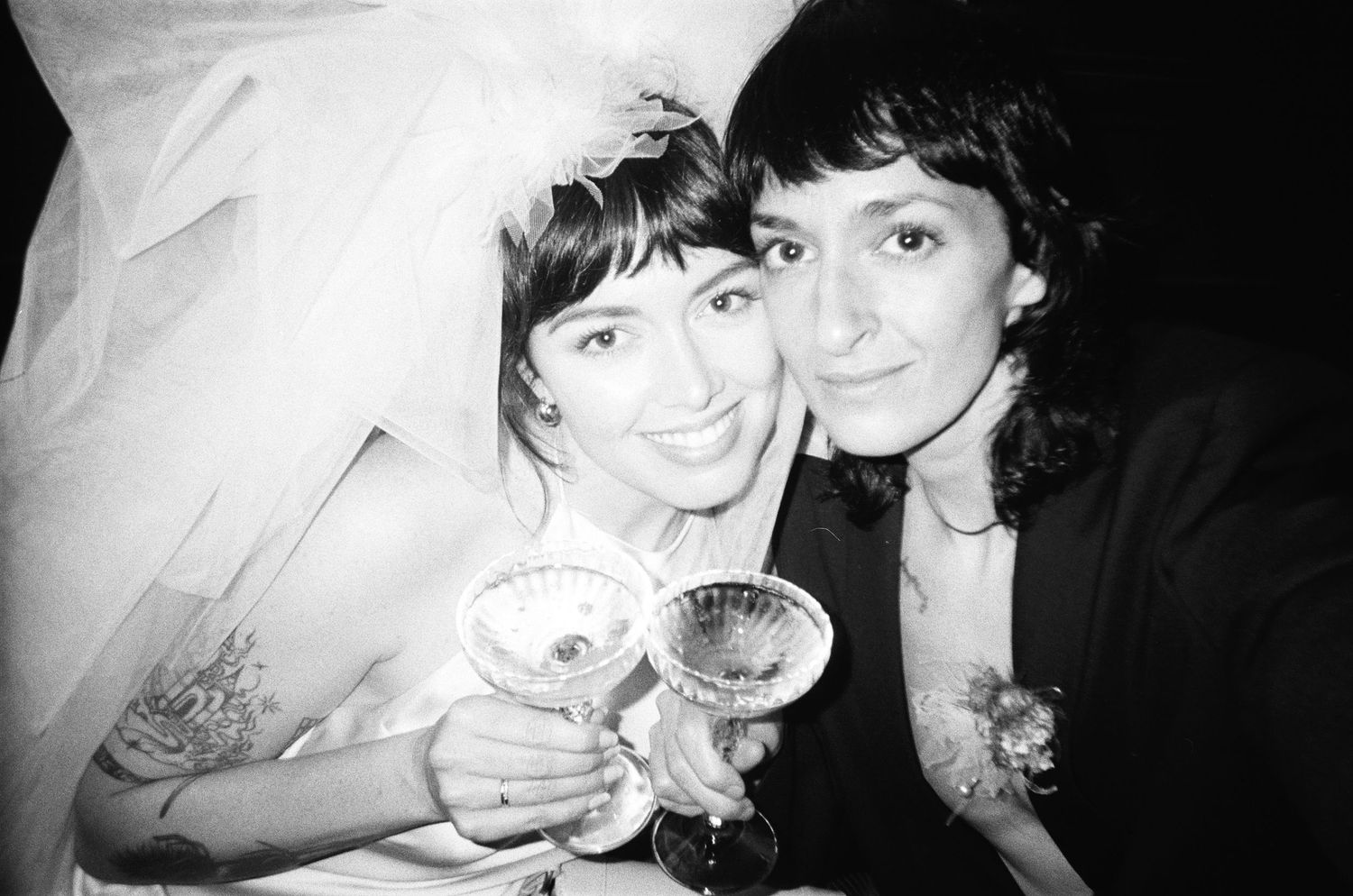 Black and white photo of married couple toasting champagne glasses.