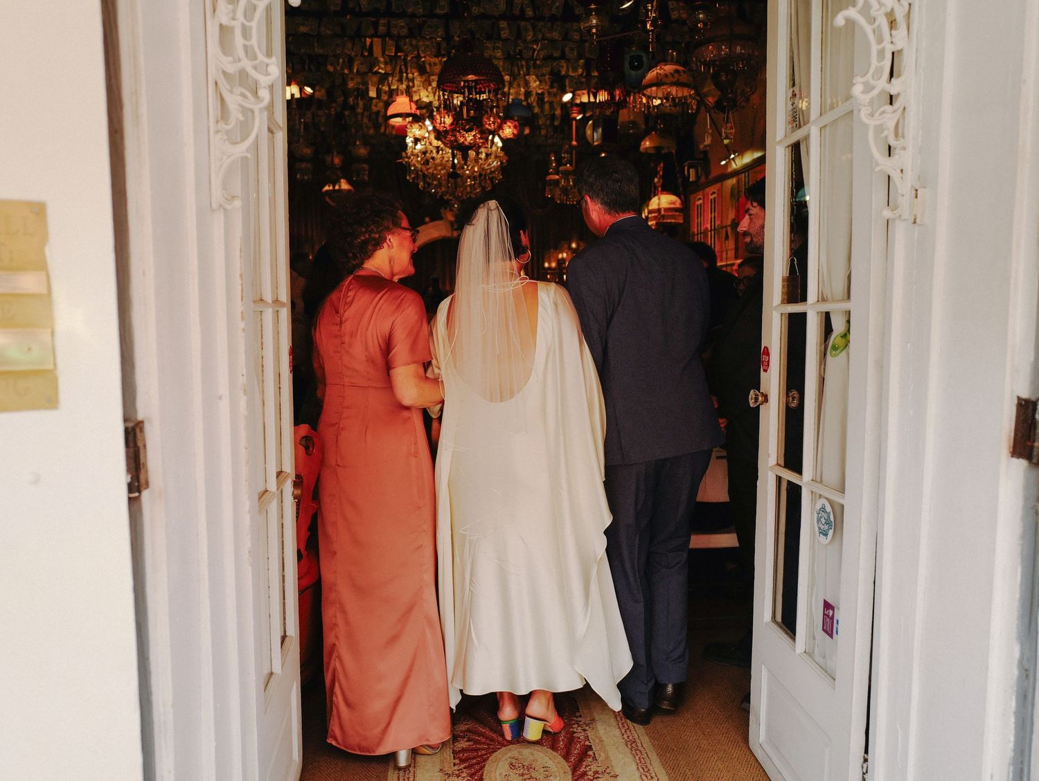 French Quarter wedding chapel entrance with ornate white doorway and guests in formal attire.