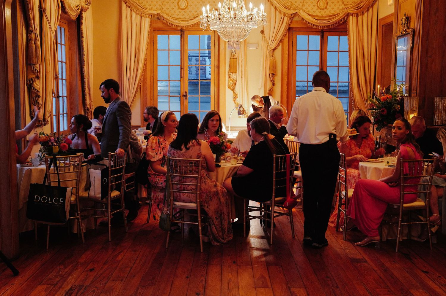 Elegant ballroom reception with crystal chandeliers and golden decor.