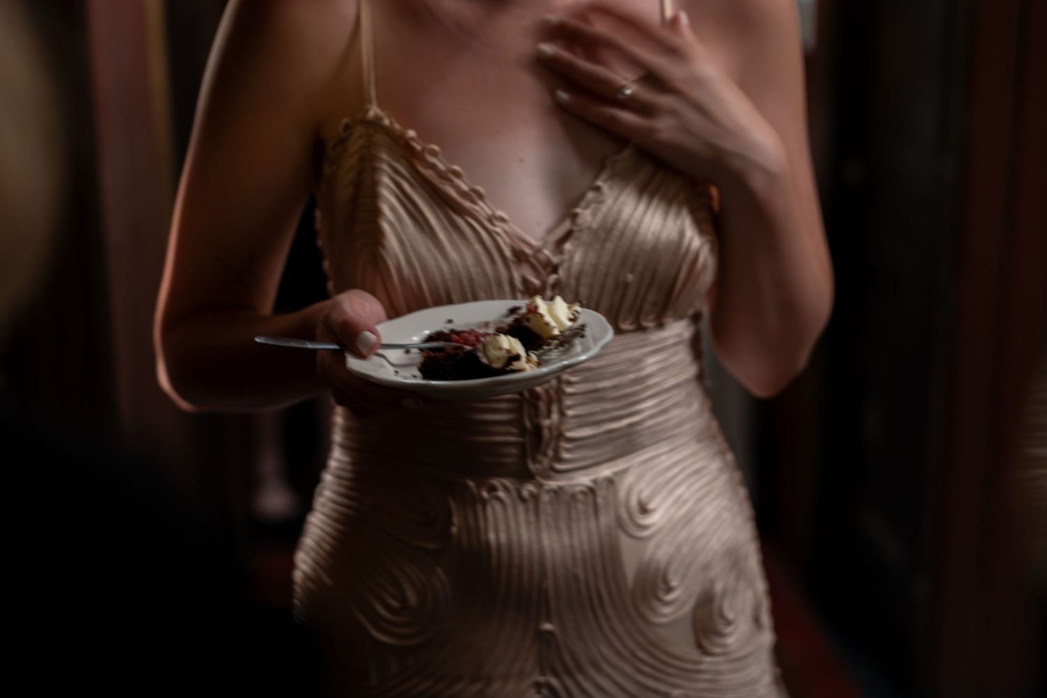 Elegant details of a wedding dress captured in dramatic low light.
