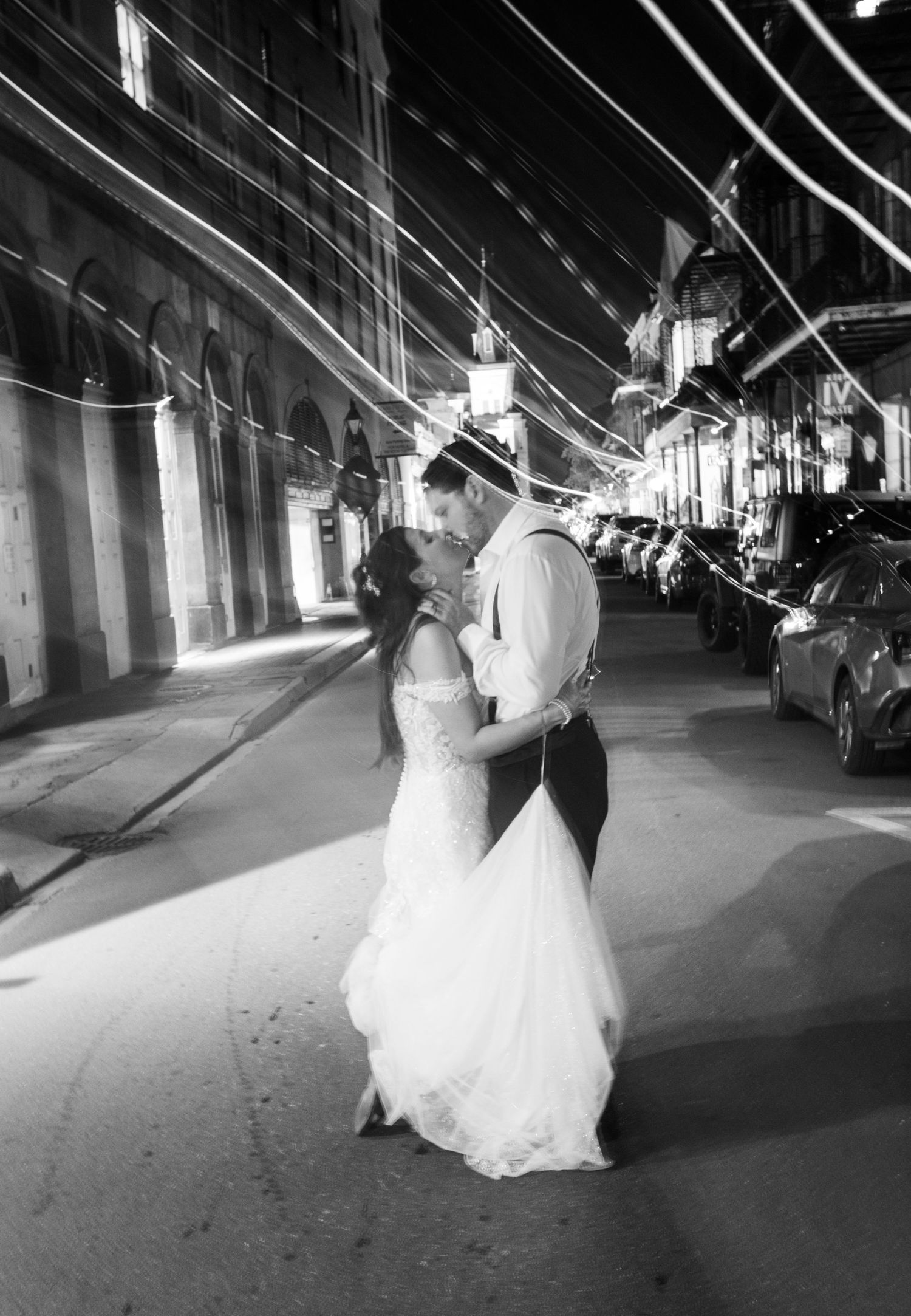 Couple dancing on a dimly lit street in formal attire in the French Quarter in New Orleans.