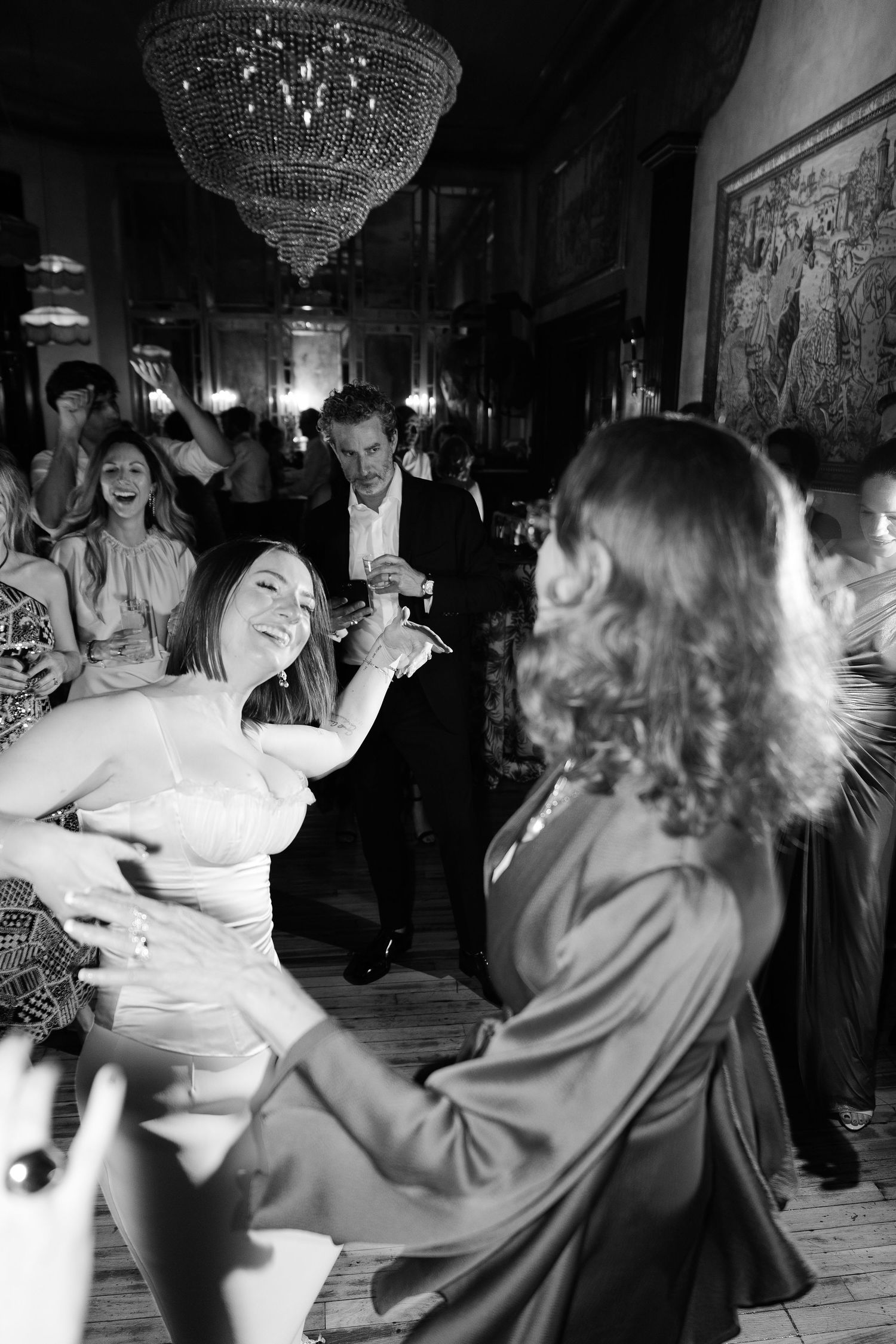 Wedding reception dancing under crystal chandelier, documentary photography by Palm Meadow Weddings