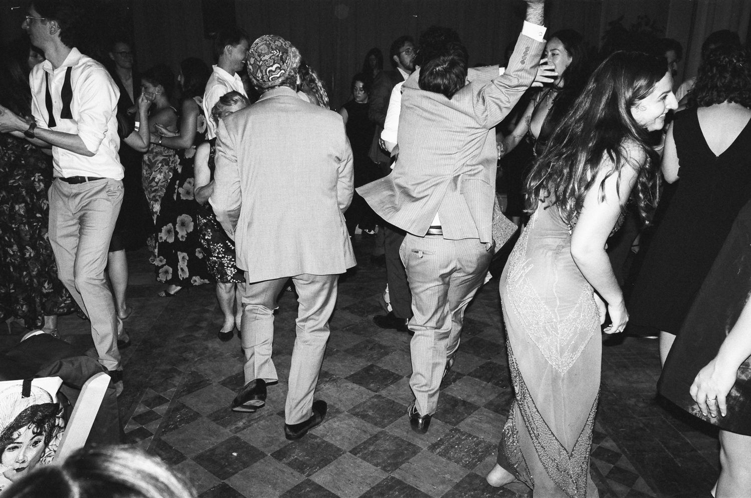 Black and white photo showing people dancing at a lively reception party.