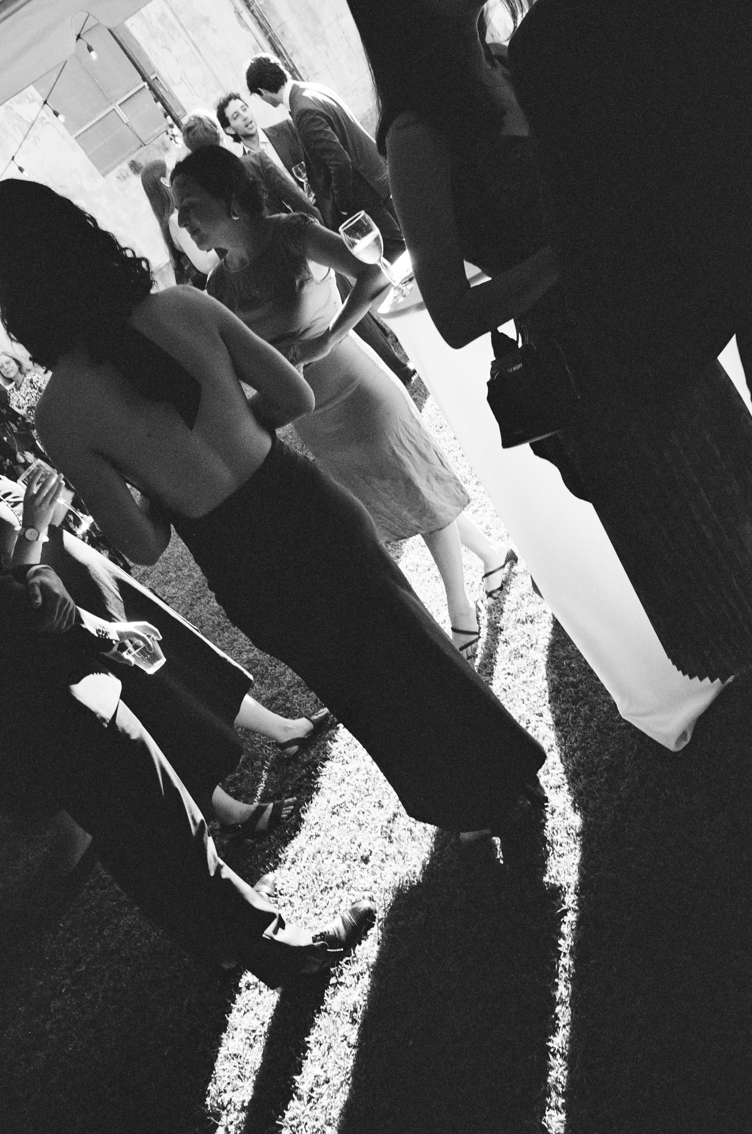 Black and white photo of people standing in line casting dramatic shadows.
