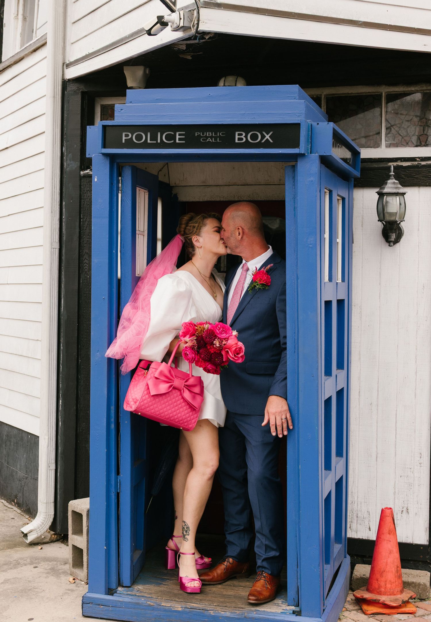 Married couple sharing a kiss in a phone booth in New Orleans.