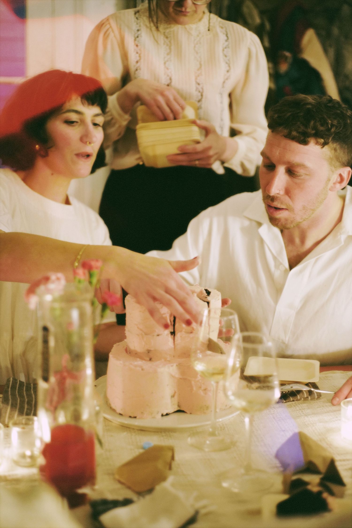 A couple cutting into a pink celebration cake at an intimate elopement.