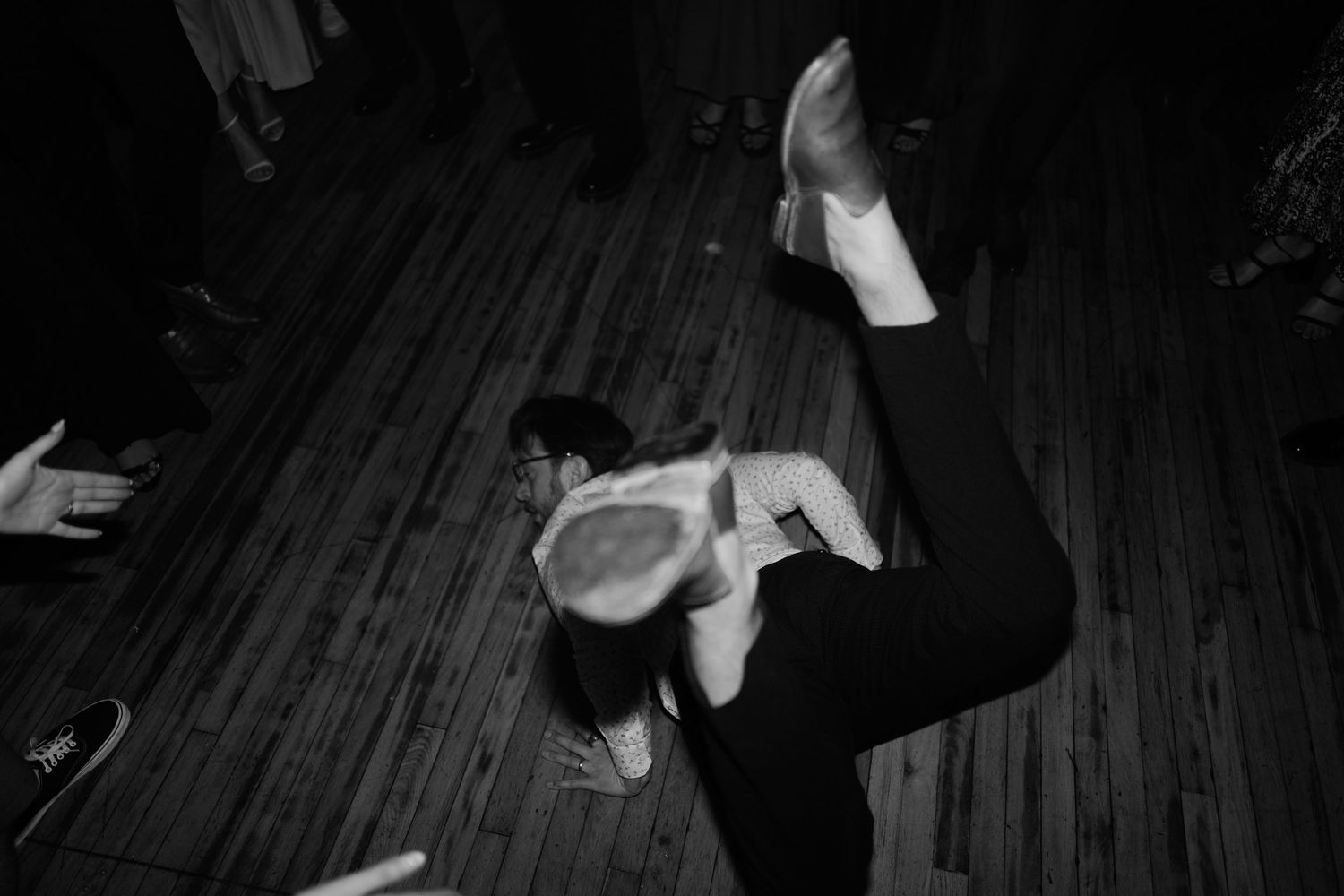 Dark silhouettes of dancers moving on a wooden floor with dramatic lighting at The Columns Hotel in New Orleans.