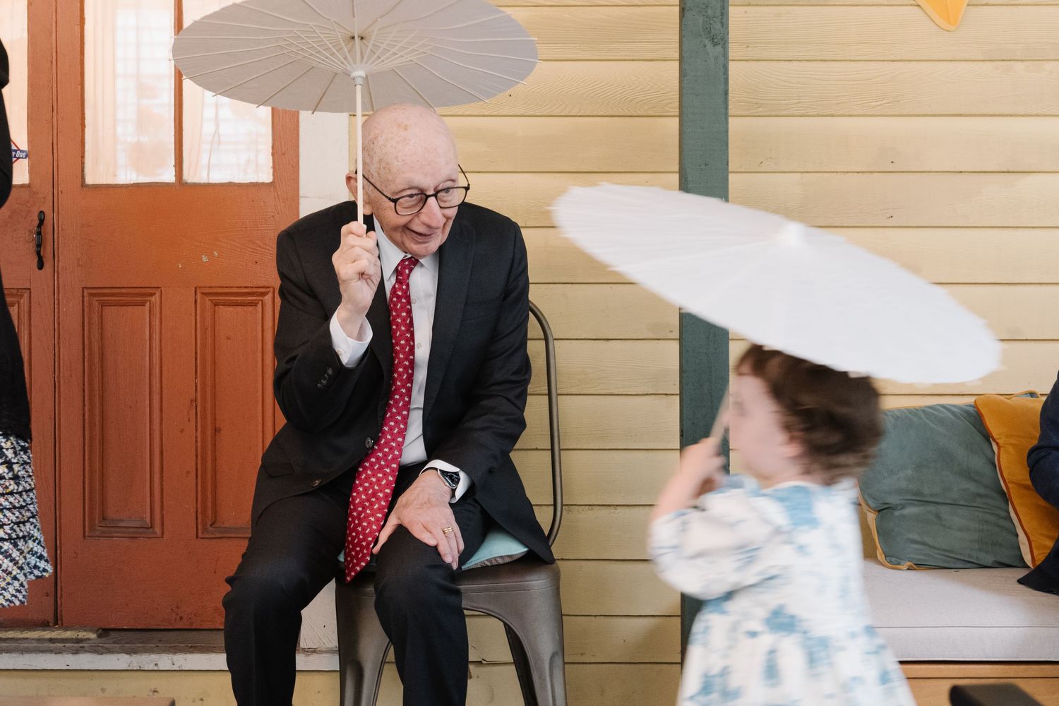 Groom with flower girl outside wedding venue, candid documentary wedding photography by Palm Meadow