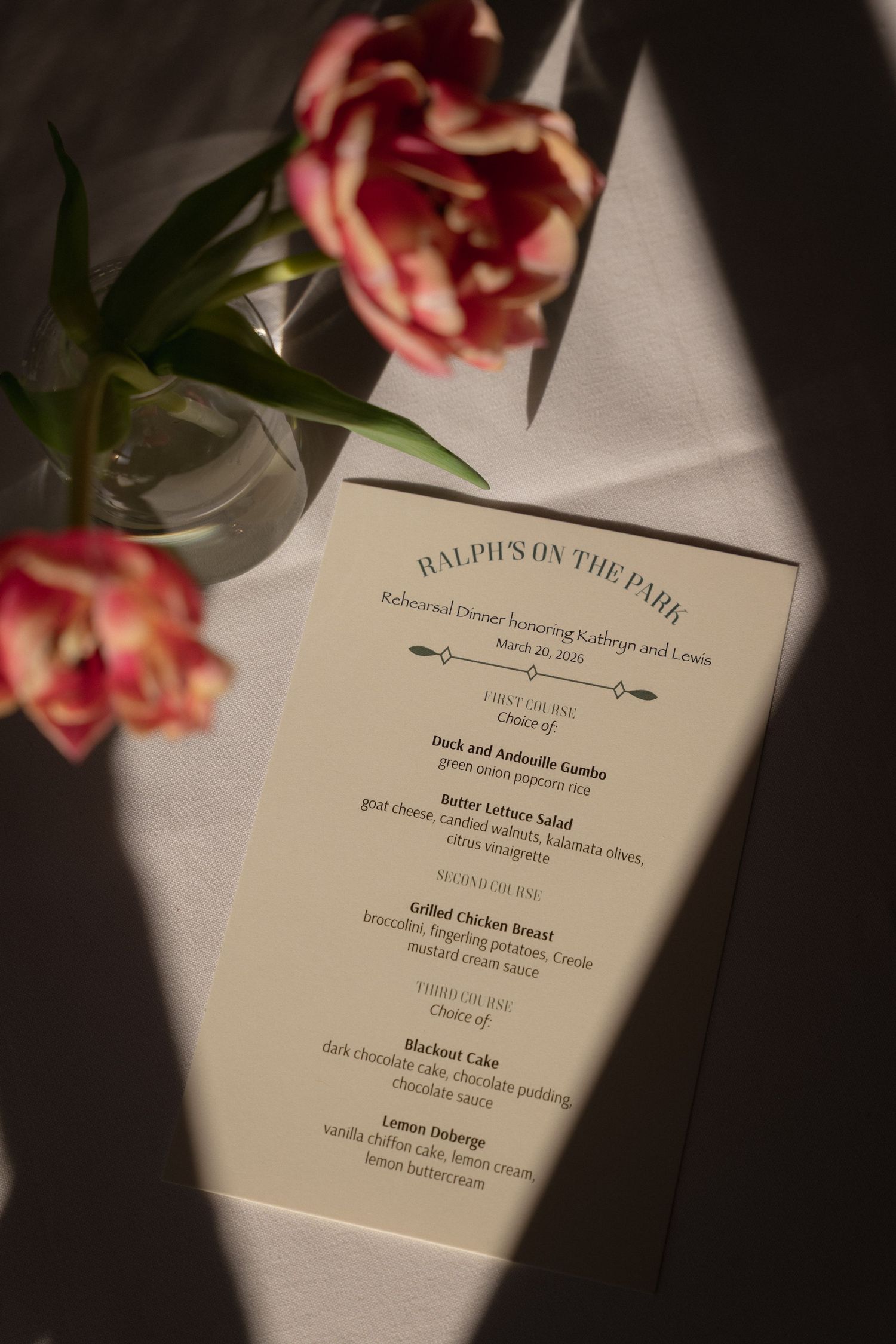 Elegant wedding rehearsal dinner menu from Ralph's on the Park with pink tulips on white linen tablecloth.
