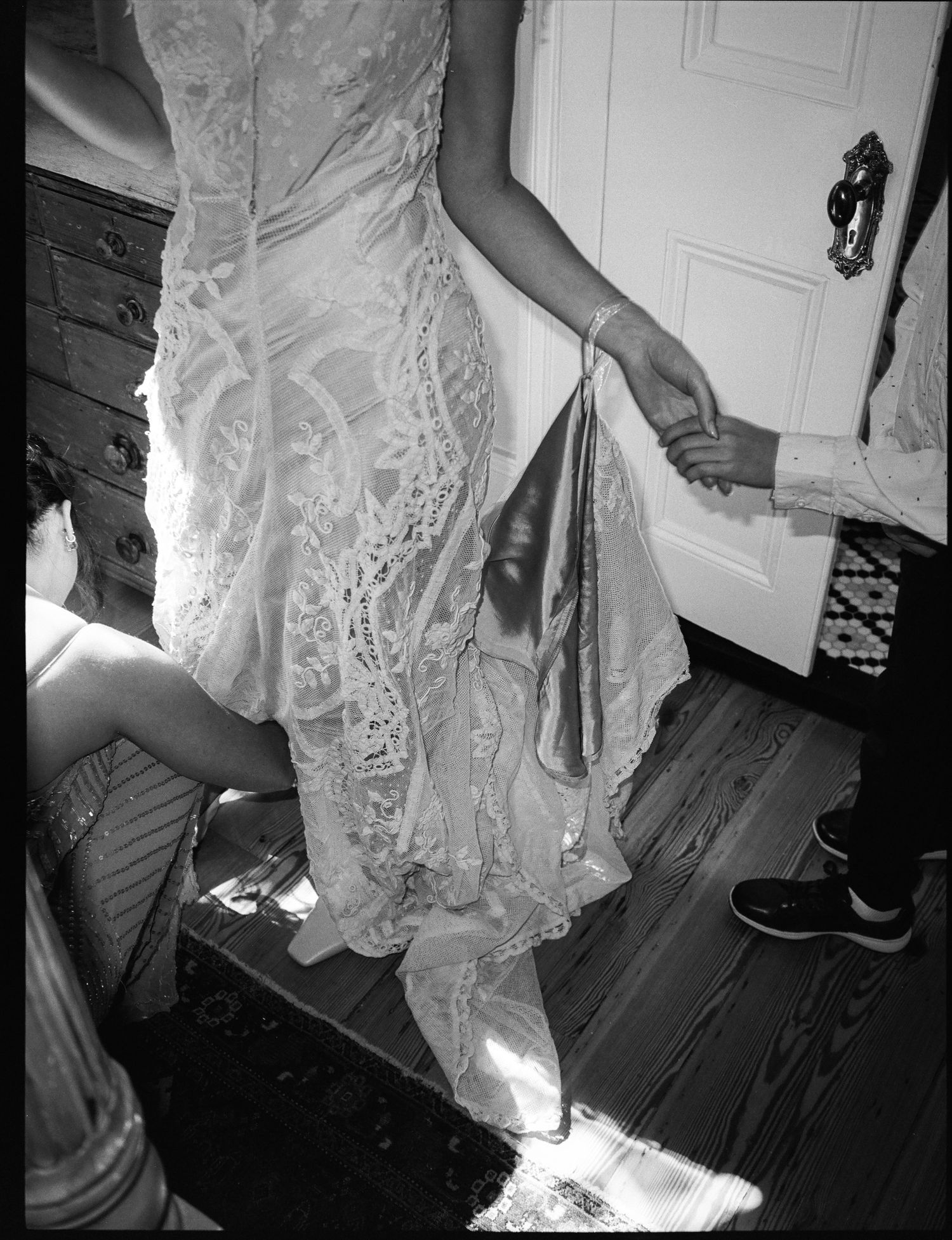 Detail shots of an ornate white lace wedding dress hem.
