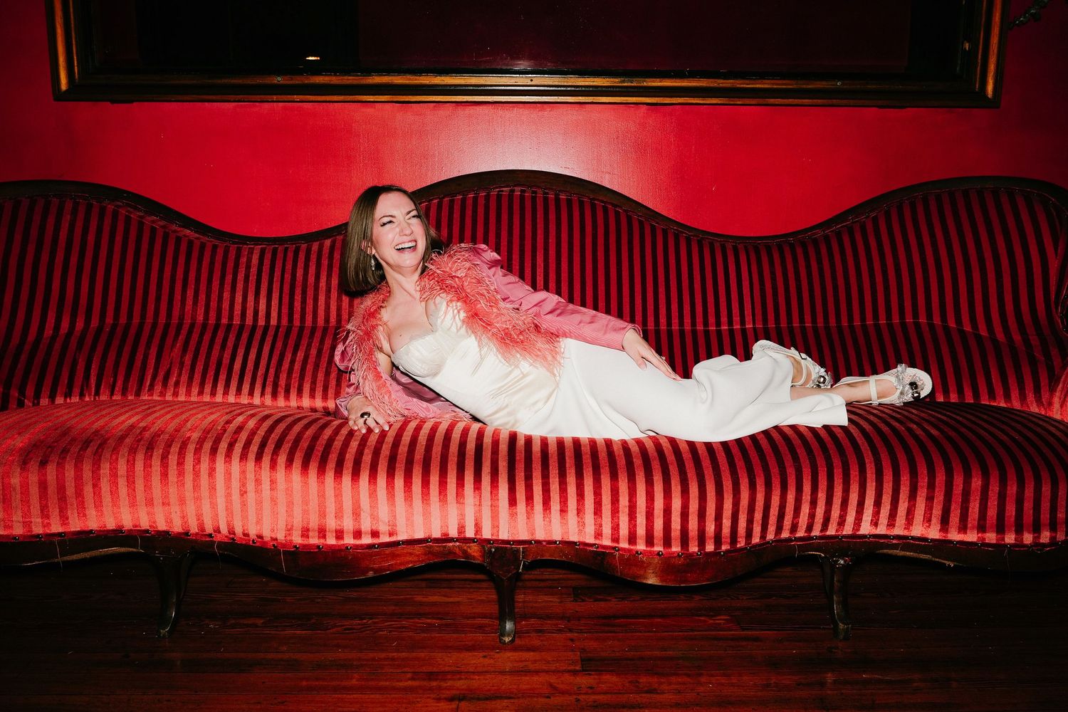 Artistic red-tinted wedding photography sequence showing movement across lounge seating.