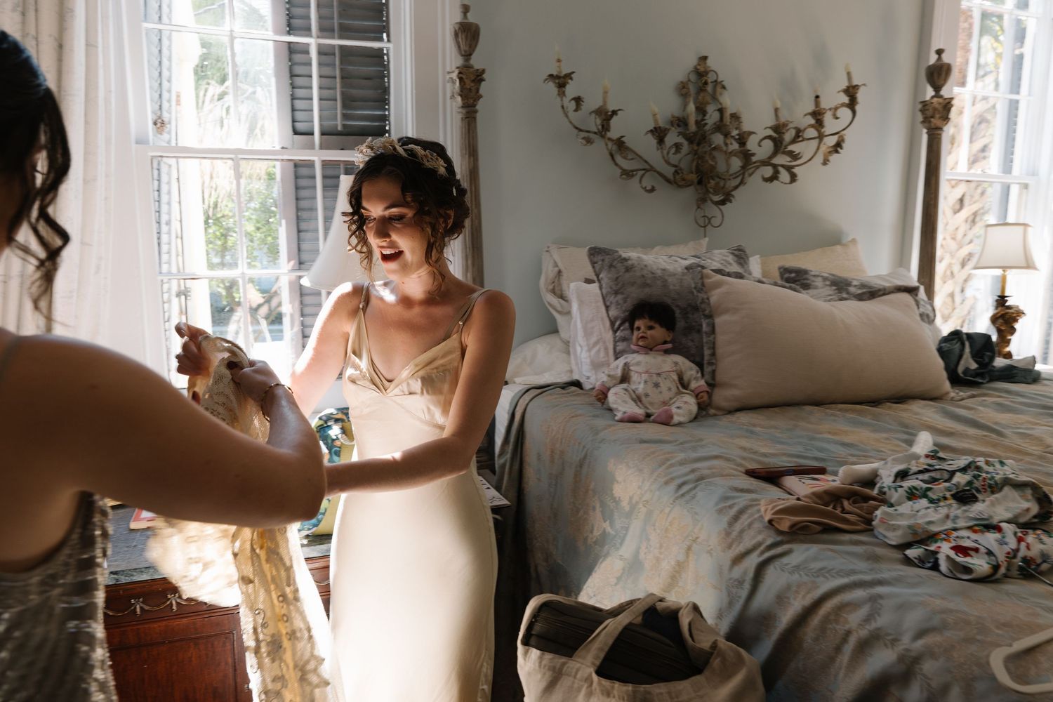 Intimate getting ready moments captured in a sunlit room with delicate lace details.