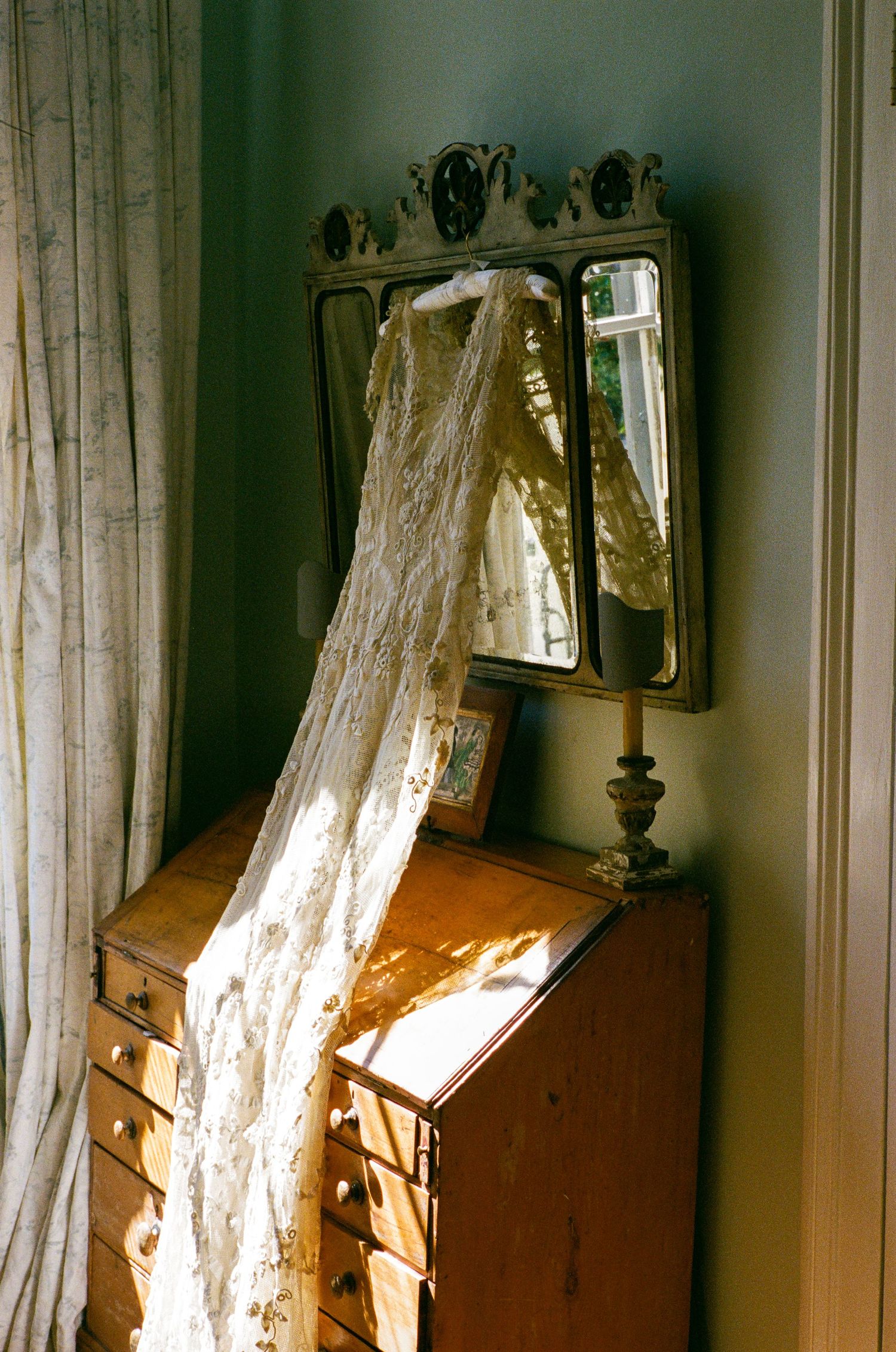 Wedding dress hanging in window light, fine art wedding photography by Palm Meadow Weddings