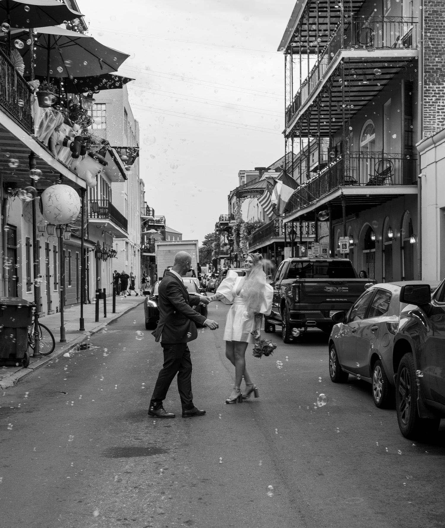 A couple dancing in the historic French Quarter of New Orleans with vintage buildings and balconies.