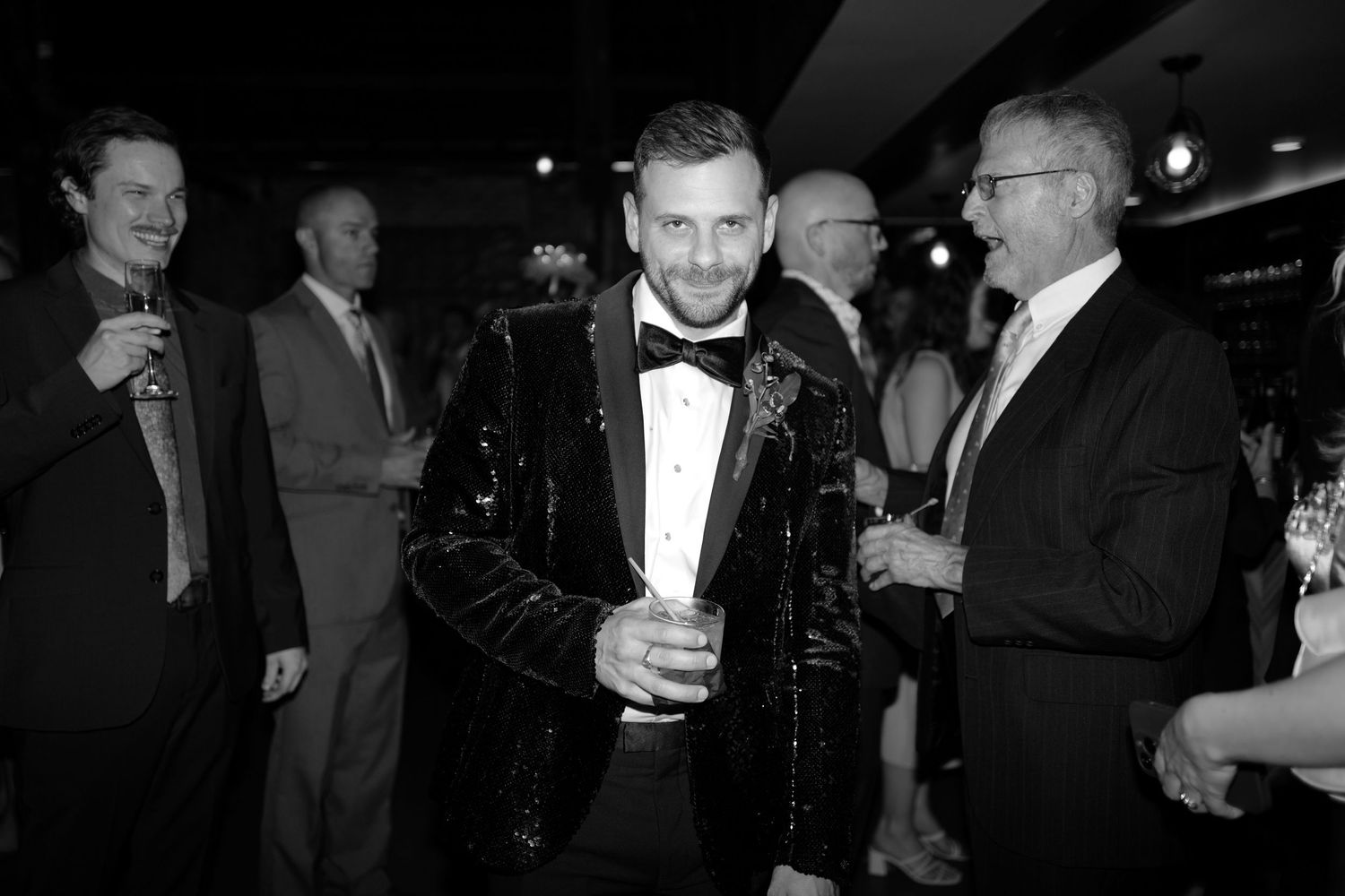 Black and white candid shots of guests mingling at an elegant wedding reception.