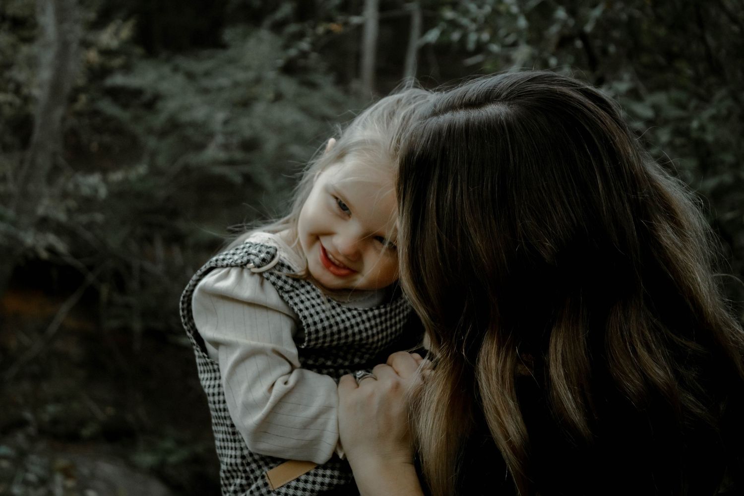 A couple in a romantic embrace shares an intimate moment in a moody outdoor setting.