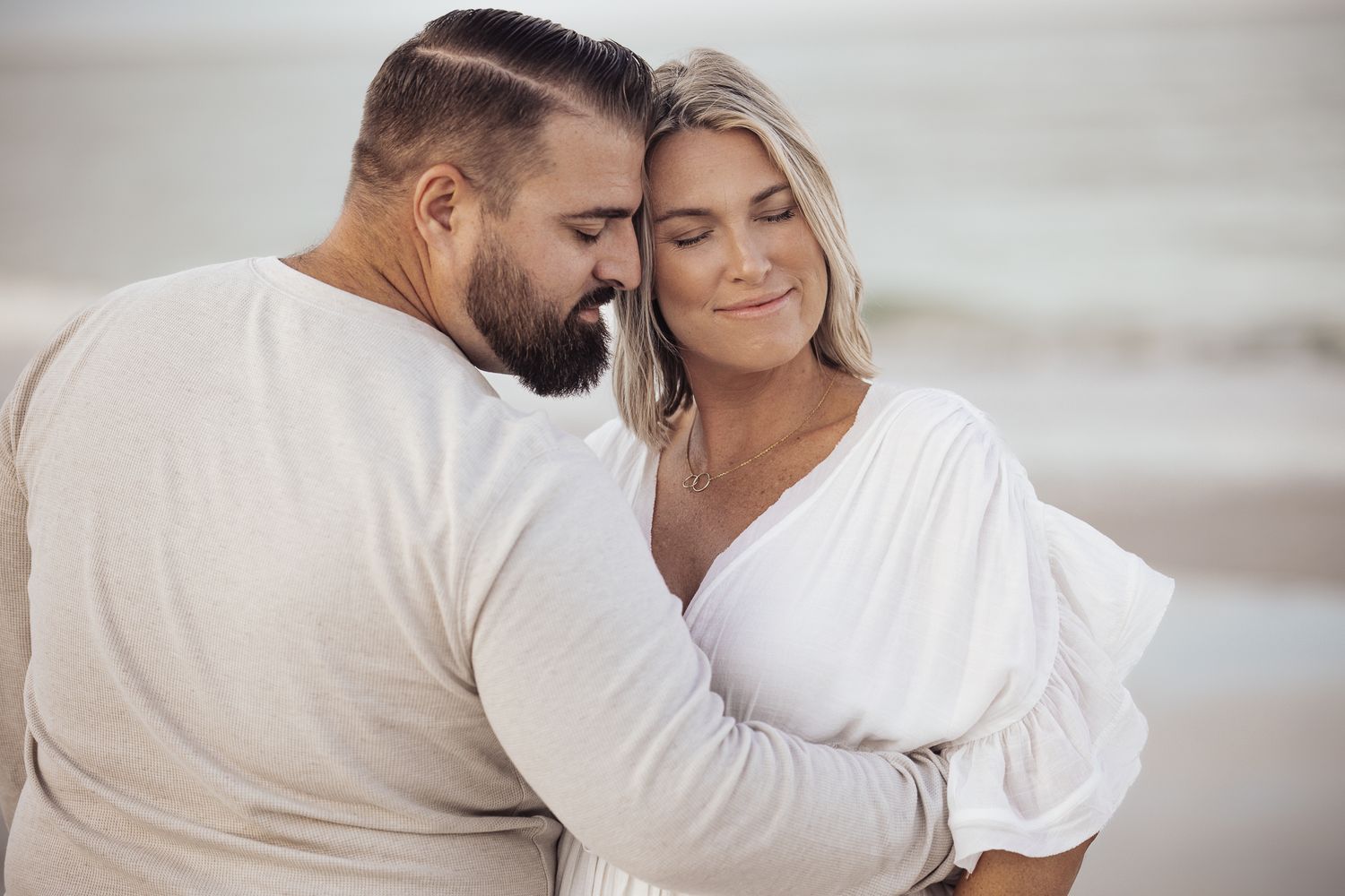 A couple shares tender moments on a beach in a series of romantic black and white photographs.