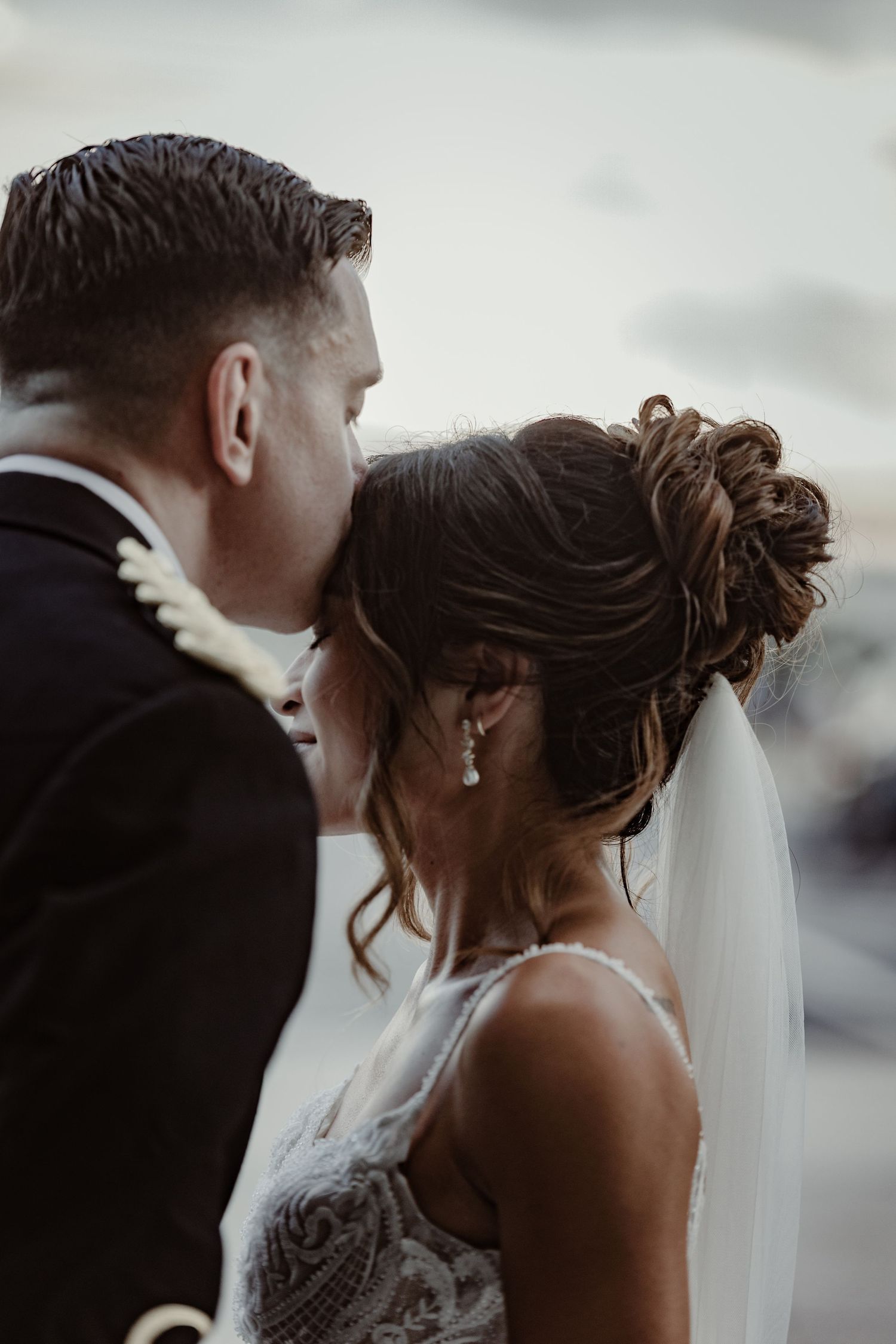 Side profile view of a bride and groom sharing an intimate moment during their wedding ceremony.