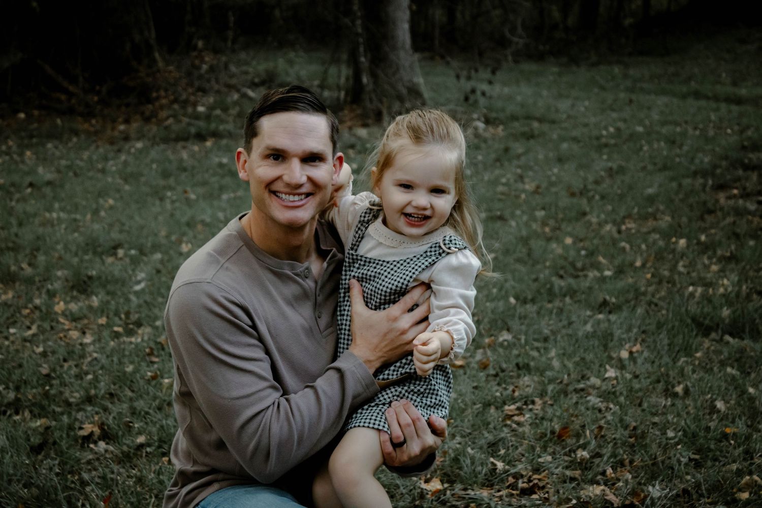 A parent and child share tender moments outdoors in a series of candid photographs on a grassy lawn.
