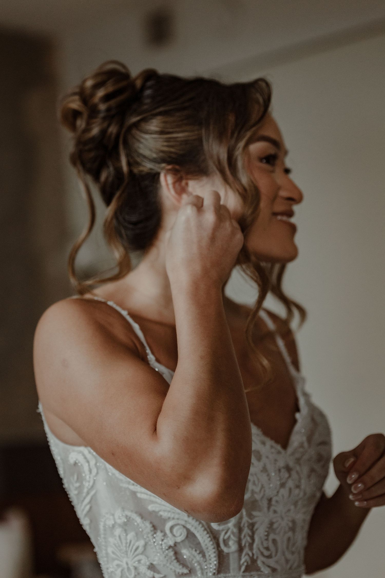 A bride in a delicate lace wedding dress with an elegant updo hairstyle is shown from different angles in moody lighting.