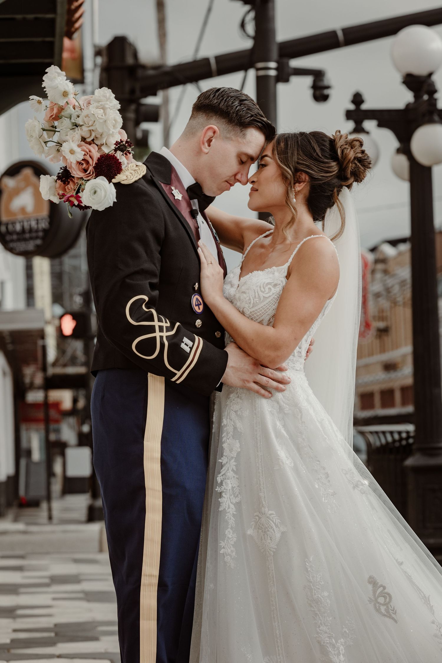 Romantic wedding couple embracing on an urban street with vintage architectural details.