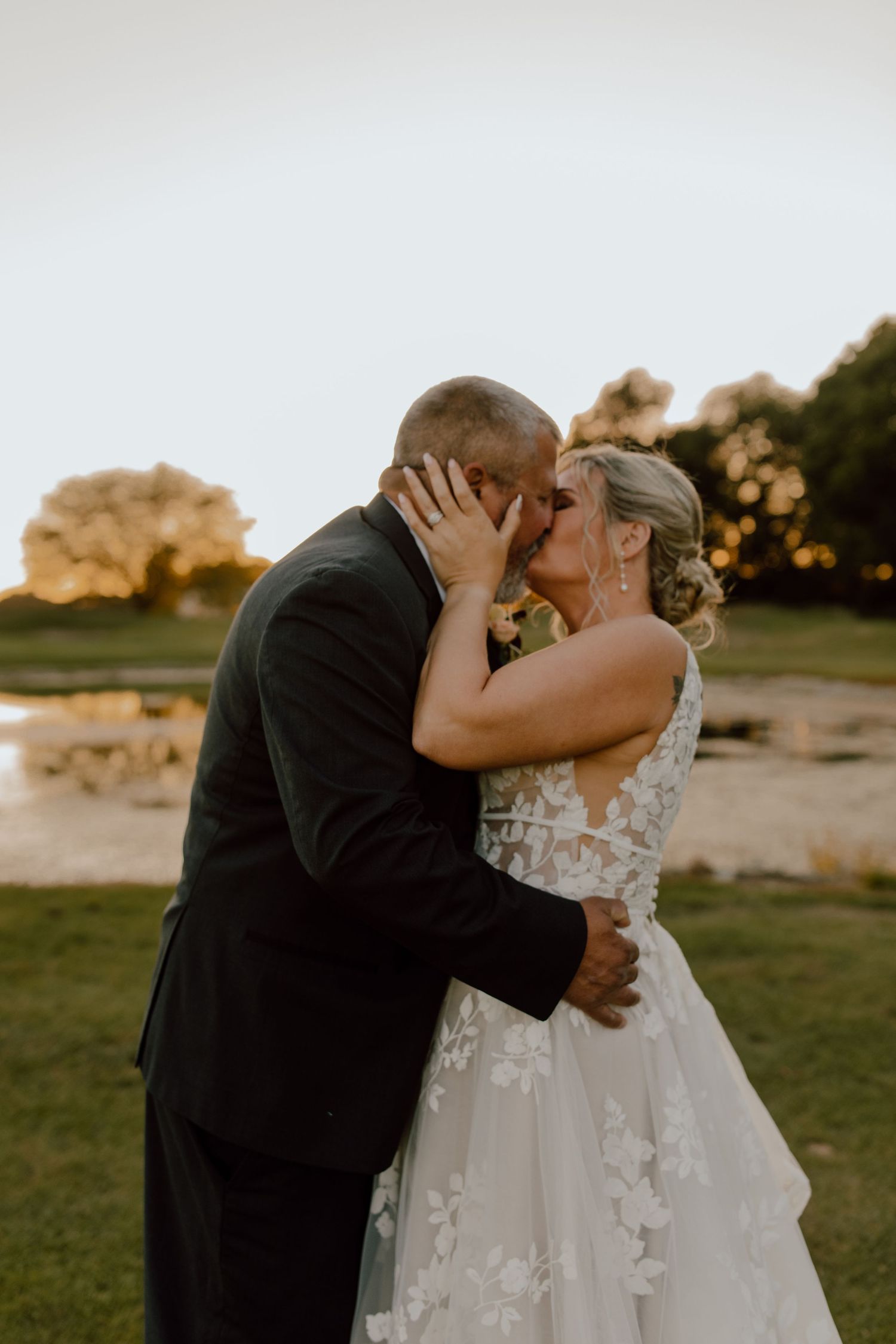 An intimate moment between newlyweds during their sunset wedding portraits outdoors.
