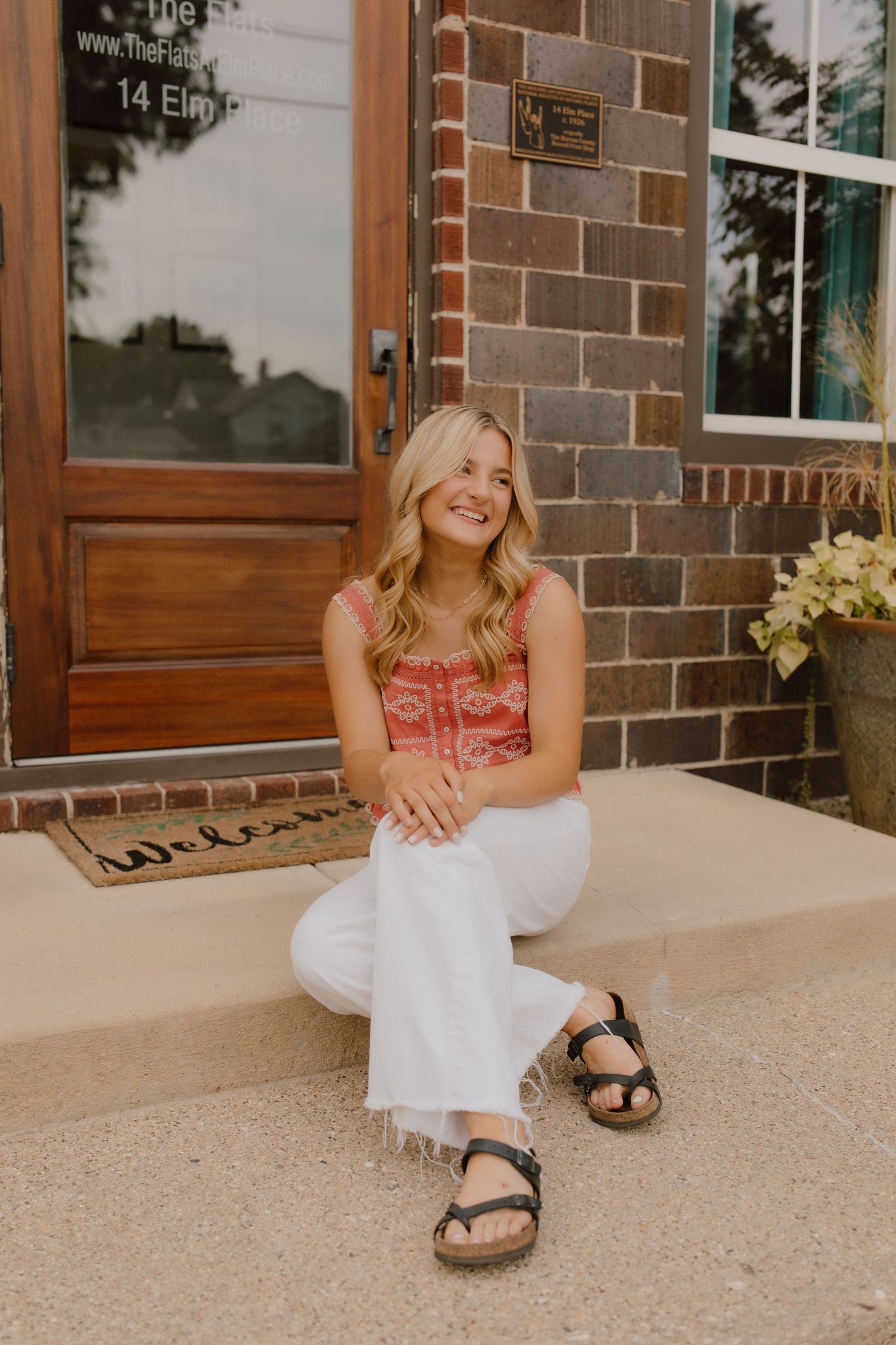 Casual portrait session outside a brick building with wooden doors.