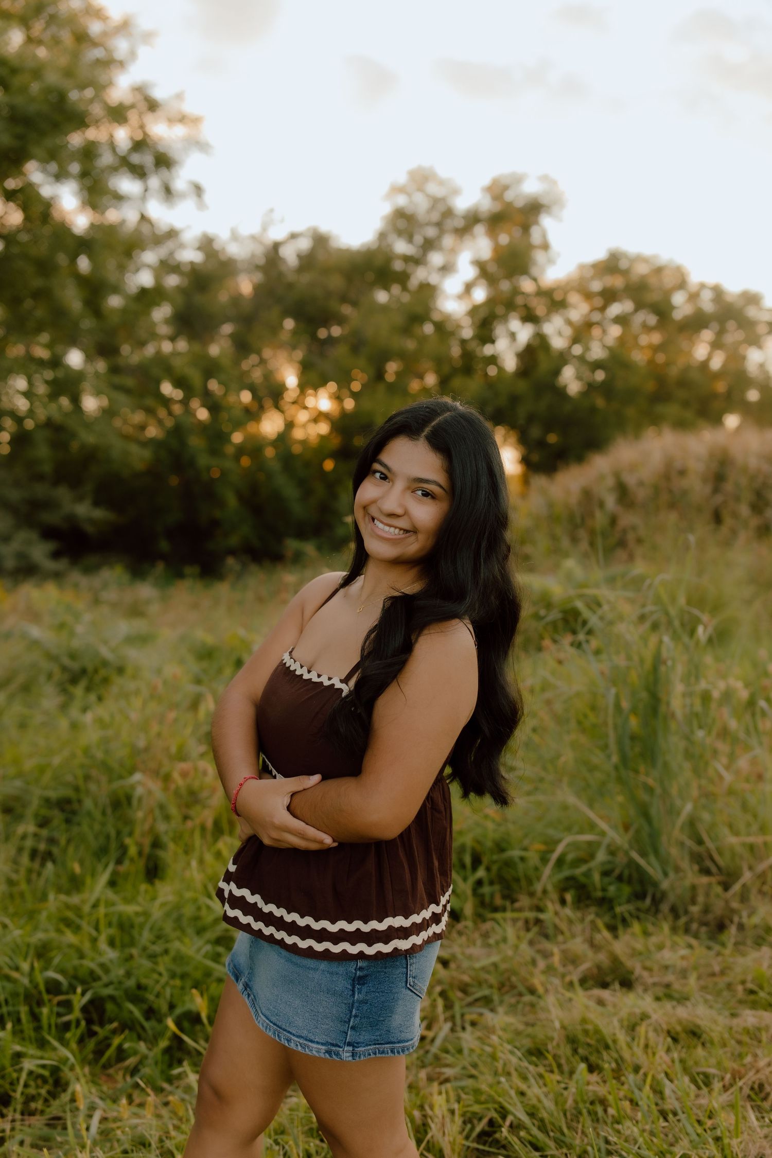 Summer outdoor portrait session in tall grass at sunset with natural lighting.