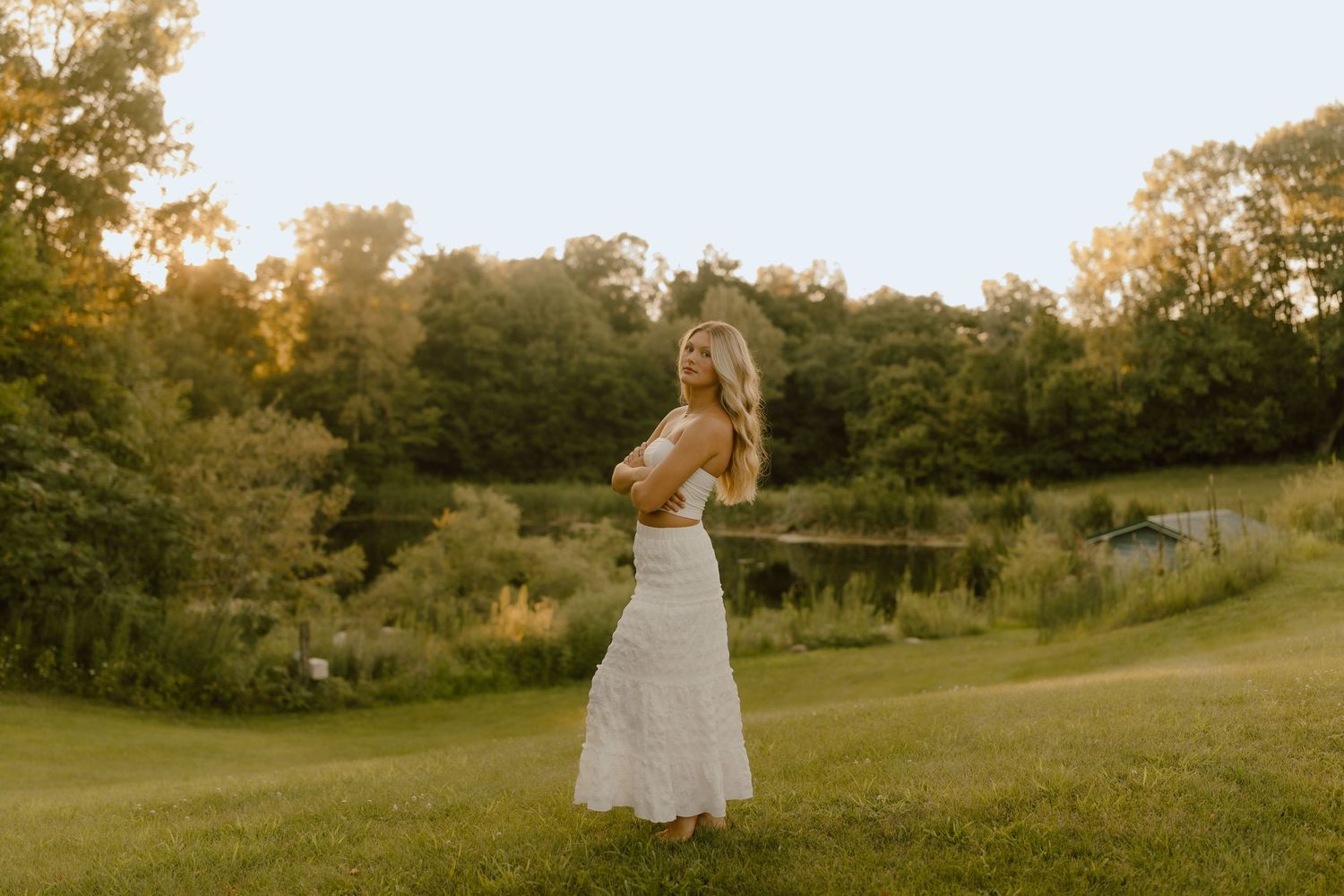 Flowing white dress captured in motion during sunset field photoshoot.