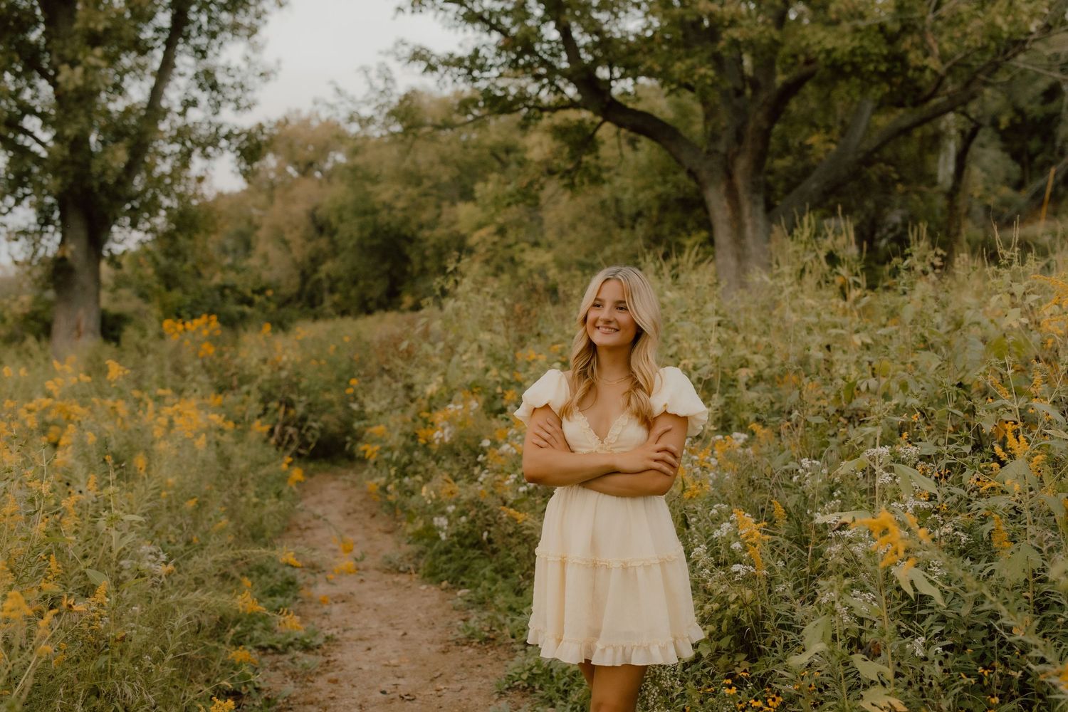 Natural light portrait session on a winding dirt path surrounded by summer wildflowers.