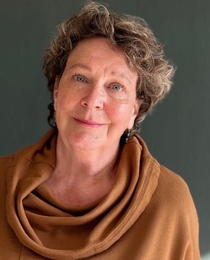 Shelley Thompson, Author, Director, and Actor based in Wolvfille, Nova Scotia; White woman with short hair and blue eyes wearing a cowl neck