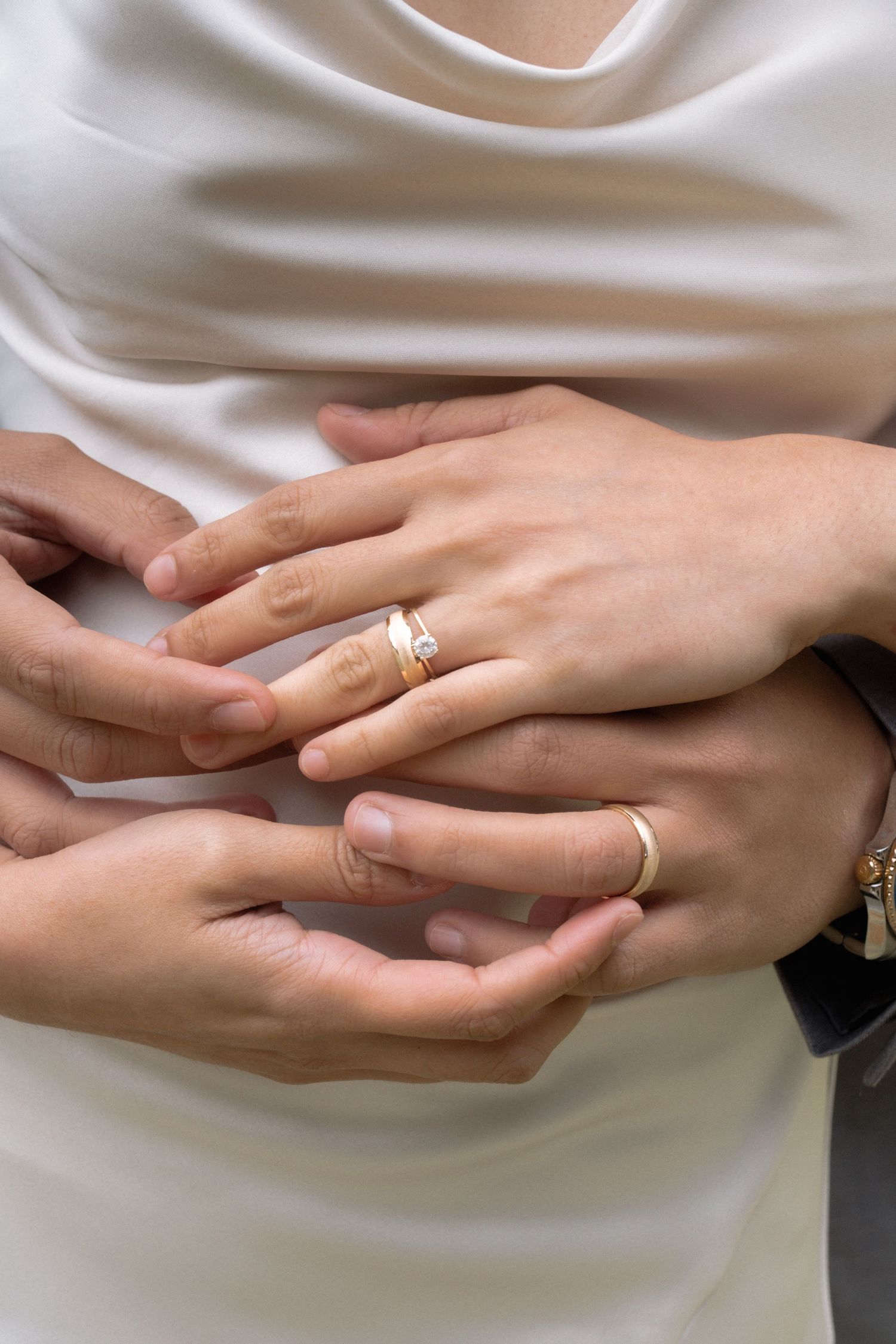 Close-up of bride and groom hands with gold wedding rings during ceremony.