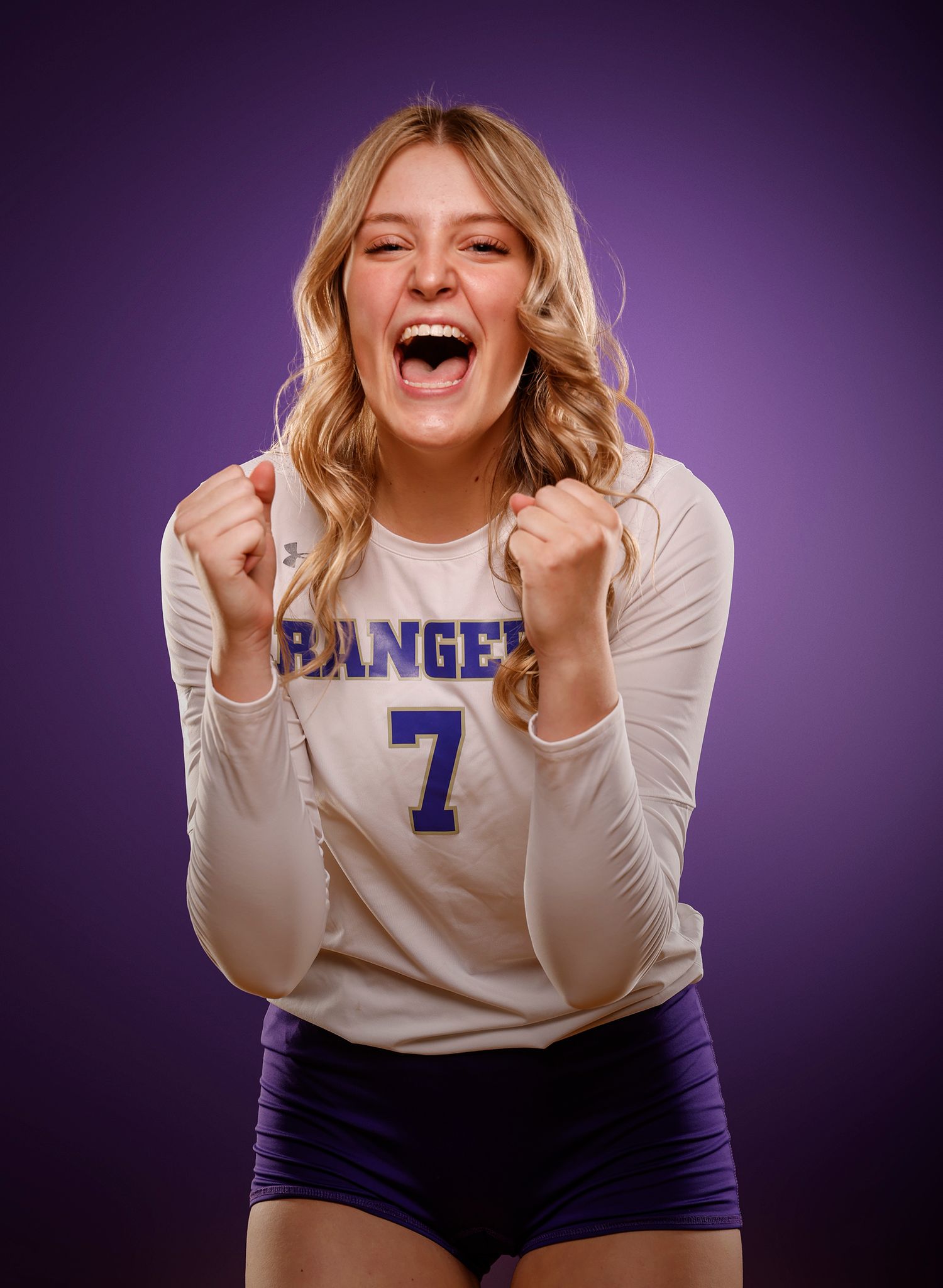 Rangers volleyball player #7 celebrates in white jersey with fists raised.